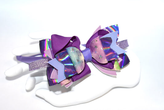 Add a pop of playful purple to your look with this bright satin headband! Thin and comfy, it’s perfect for all ages who love a splash of color. Whether you're young or young at heart, Nana’s Headband Collection 11 is your go-to for fun style and easy wear! 💜✨🎀