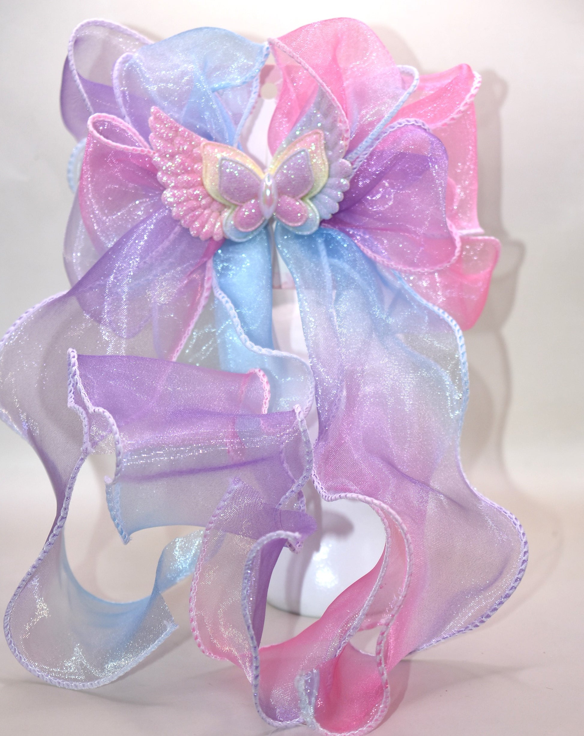 Add a splash of fun with this vibrant fish tail ribbon bow, bursting with all the colors of the rainbow 🌈! A charming butterfly with delicate wings adds an extra touch of whimsy 🦋. Secured with a French barrette clip, it stays put while you play and dance. Perfect for brightening up any outfit with playful style!