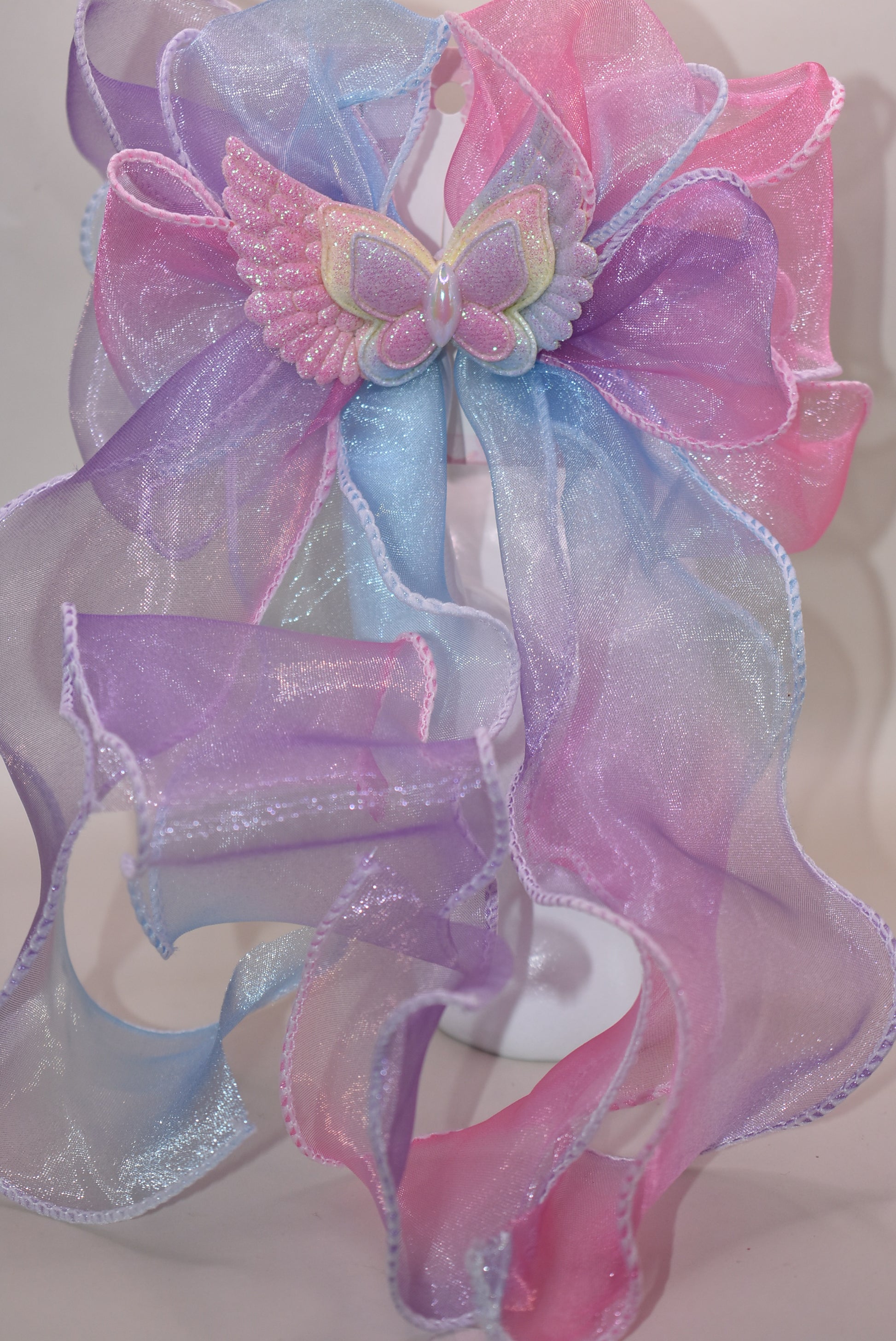 Add a splash of fun with this vibrant fish tail ribbon bow, bursting with all the colors of the rainbow 🌈! A charming butterfly with delicate wings adds an extra touch of whimsy 🦋. Secured with a French barrette clip, it stays put while you play and dance. Perfect for brightening up any outfit with playful style!