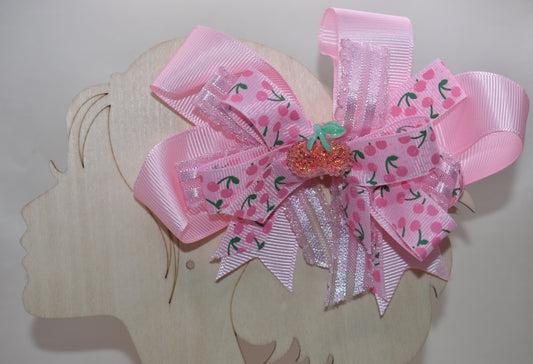 Adorable cherry-themed bow featuring delicate layers of soft pink ribbon that create a charming, dimensional look. The covered alligator clip ensures comfortable wear throughout the day without slipping or pinching. Perfect for adding a sweet pop of personality to any hairstyle, this precious accessory is designed to make you smile every time you catch your reflection. A delightful addition to Nana's Collection that celebrates timeless charm and playful style.