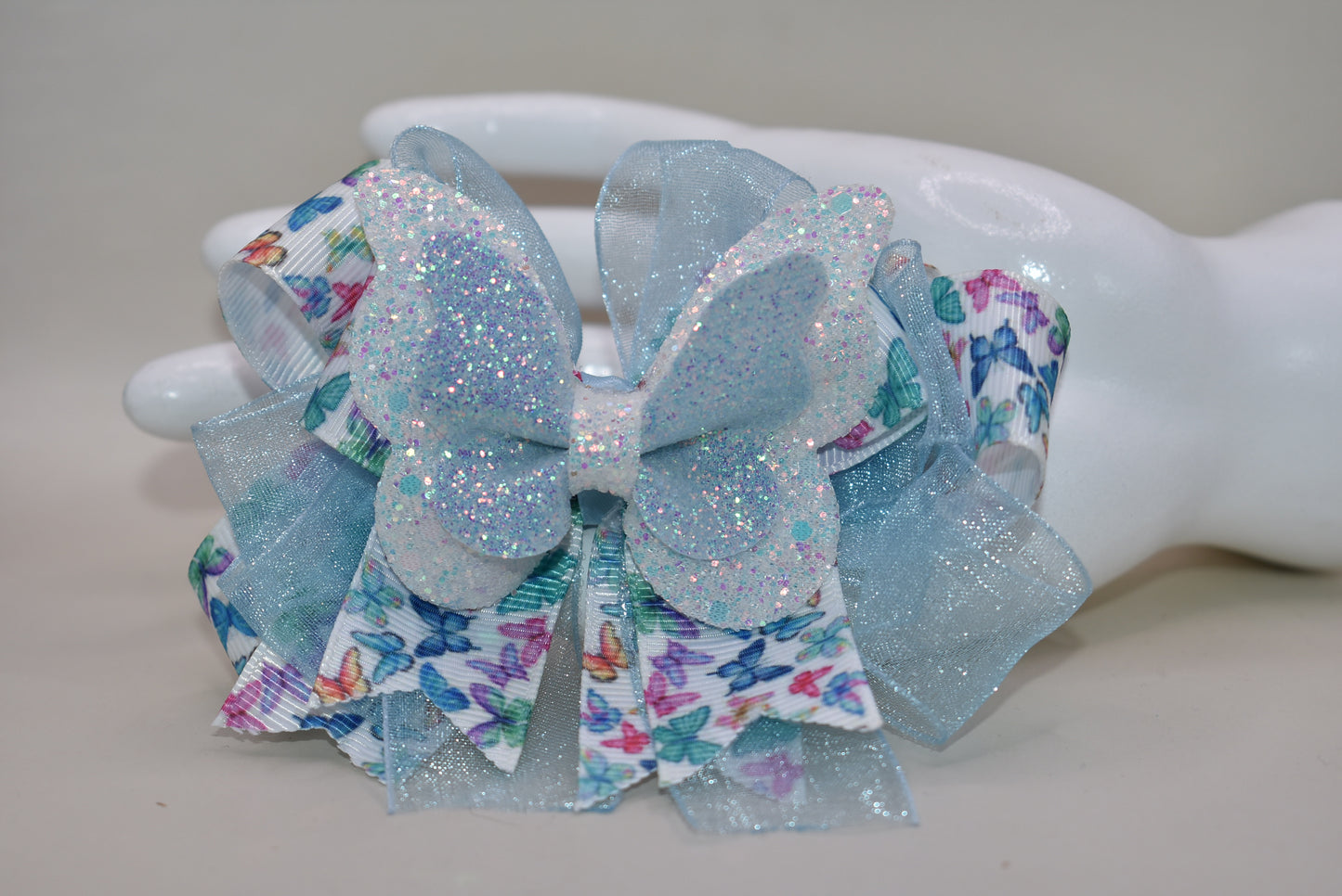✨ Introducing a whimsical accessory straight from Nana's Collection! This enchanting blue butterfly bow features delicate multi-colored ribbon details and luxurious layered fabric that catches the light beautifully. 🦋 The wrapped alligator clip makes it effortless to secure in your hair, keeping your style picture-perfect all day long. Perfect for adding a touch of charm and personality to any look! 💙🎀