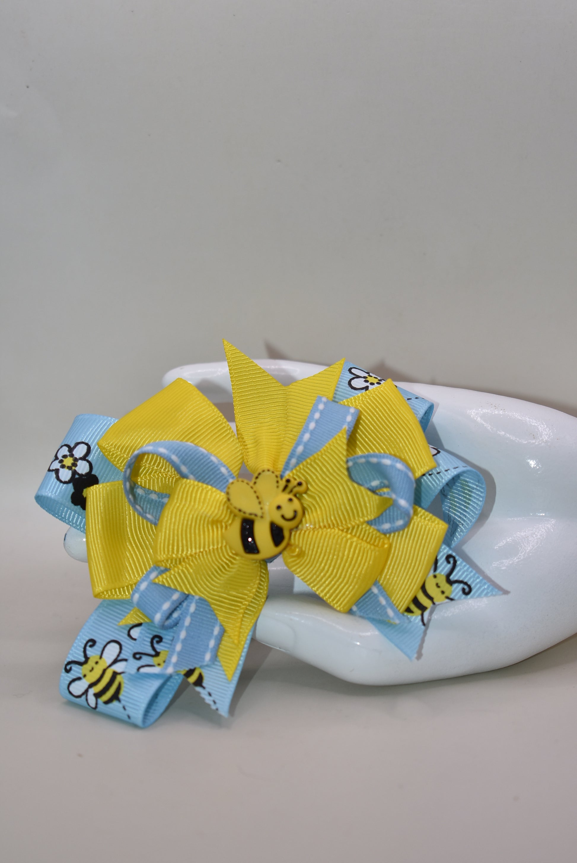 🐝 Introducing the sweetest addition to your little one's accessory collection! This adorable bumble bee bow features delightful layers of ribbon that create texture and charm. Perfect for adding a pop of personality to any outfit, from casual playdates to special occasions. Watch your child's face light up when they see this fun, buzzing accessory! 🎀✨ A playful must-have that brings joy and style together.
