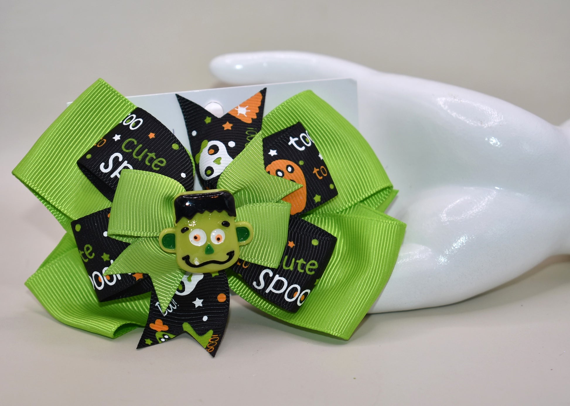 Get ready to spook in style with the cutest little Frankenstein ever! 🎃🧟♂️ Perched atop a fun green and black ribbon, this alligator clip makes wearing it a breeze. Perfect for all ages, it adds a playful touch to your Halloween look. 👻🖤💚