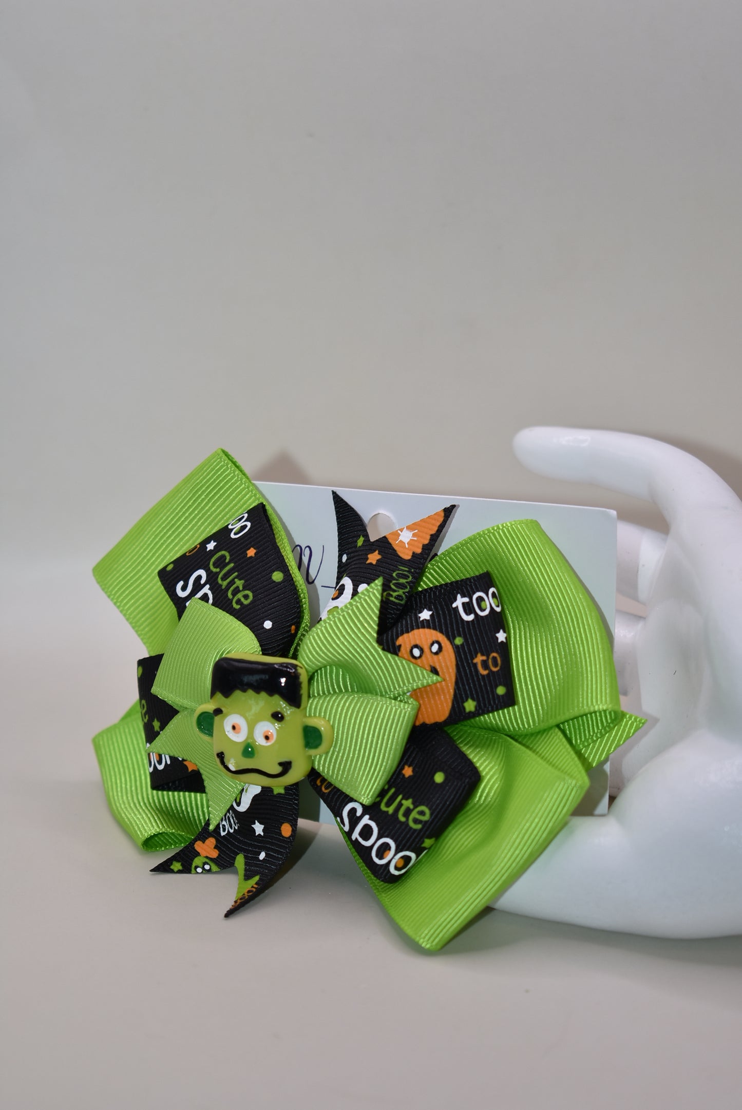 Get ready to spook in style with the cutest little Frankenstein ever! 🎃🧟♂️ Perched atop a fun green and black ribbon, this alligator clip makes wearing it a breeze. Perfect for all ages, it adds a playful touch to your Halloween look. 👻🖤💚