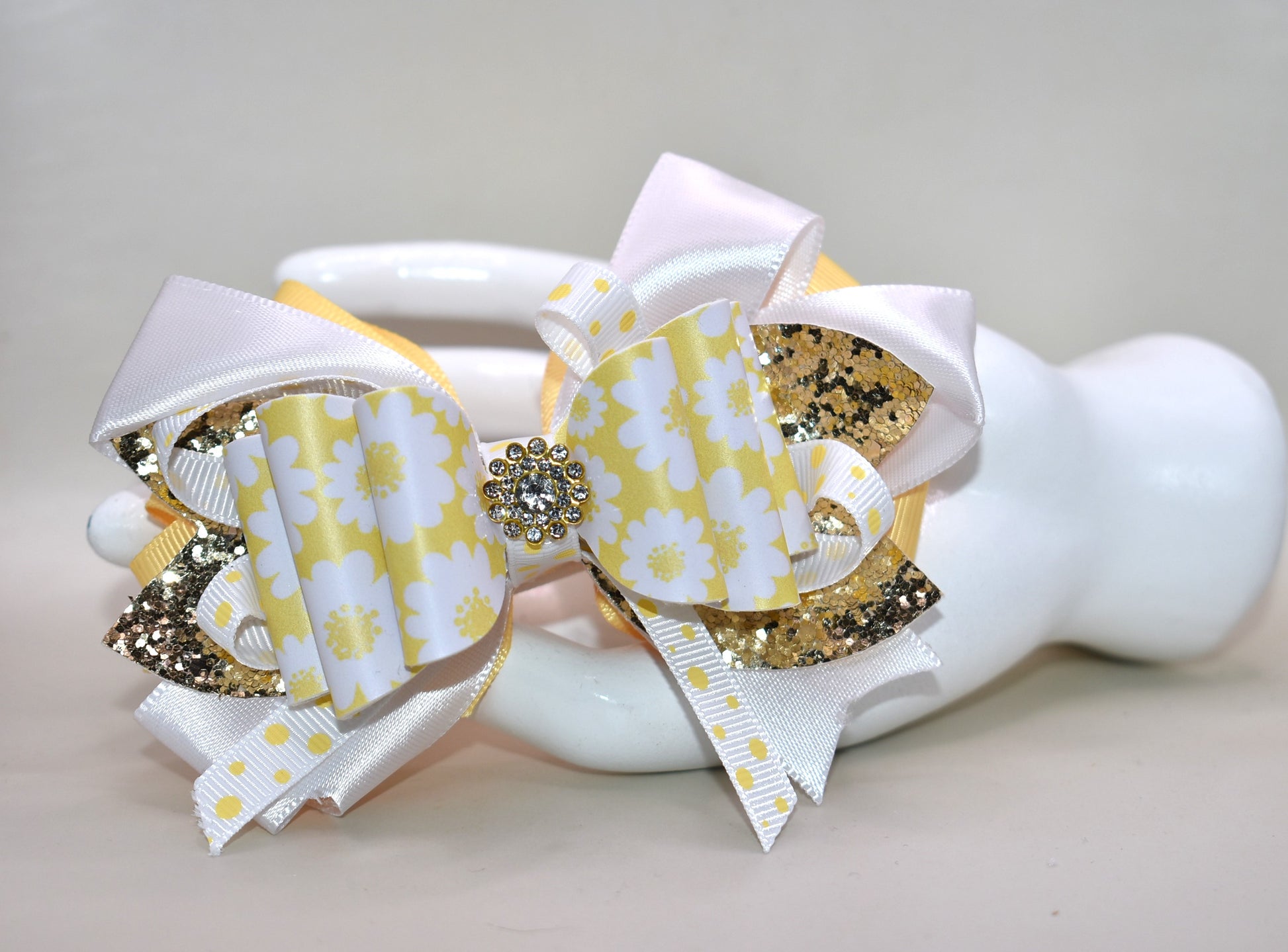 ✨ Brighten up any look with this cheerful bow featuring vibrant yellow and white ribbon paired with shimmering gold glitter faux leather! 🎀 The perfect pop of fun that works with whatever you're wearing—casual or dressed up, this accessory is your go-to style companion. 💛 Secured with a wrapped alligator clip on the back for effortless, all-day wear. 🌟