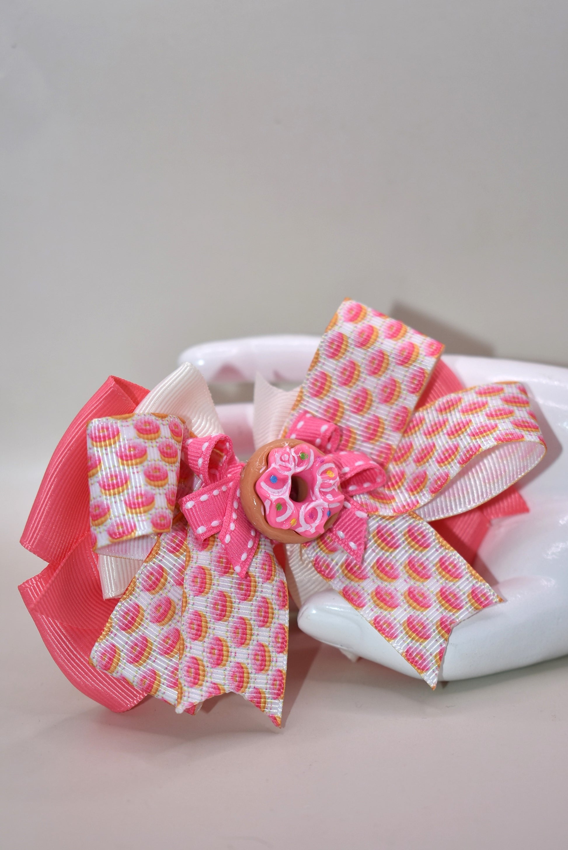 Get ready to sprinkle some sweetness into your day! 🍩 This adorable donut-themed bow features vibrant pink and colorful ribbons layered with playful charm. The wrapped alligator clip on the back makes it super easy to secure in your hair, so you can rock your donut dreams from morning to night. Perfect for anyone who loves a little whimsy and wants to show off their fun side! 🎀✨