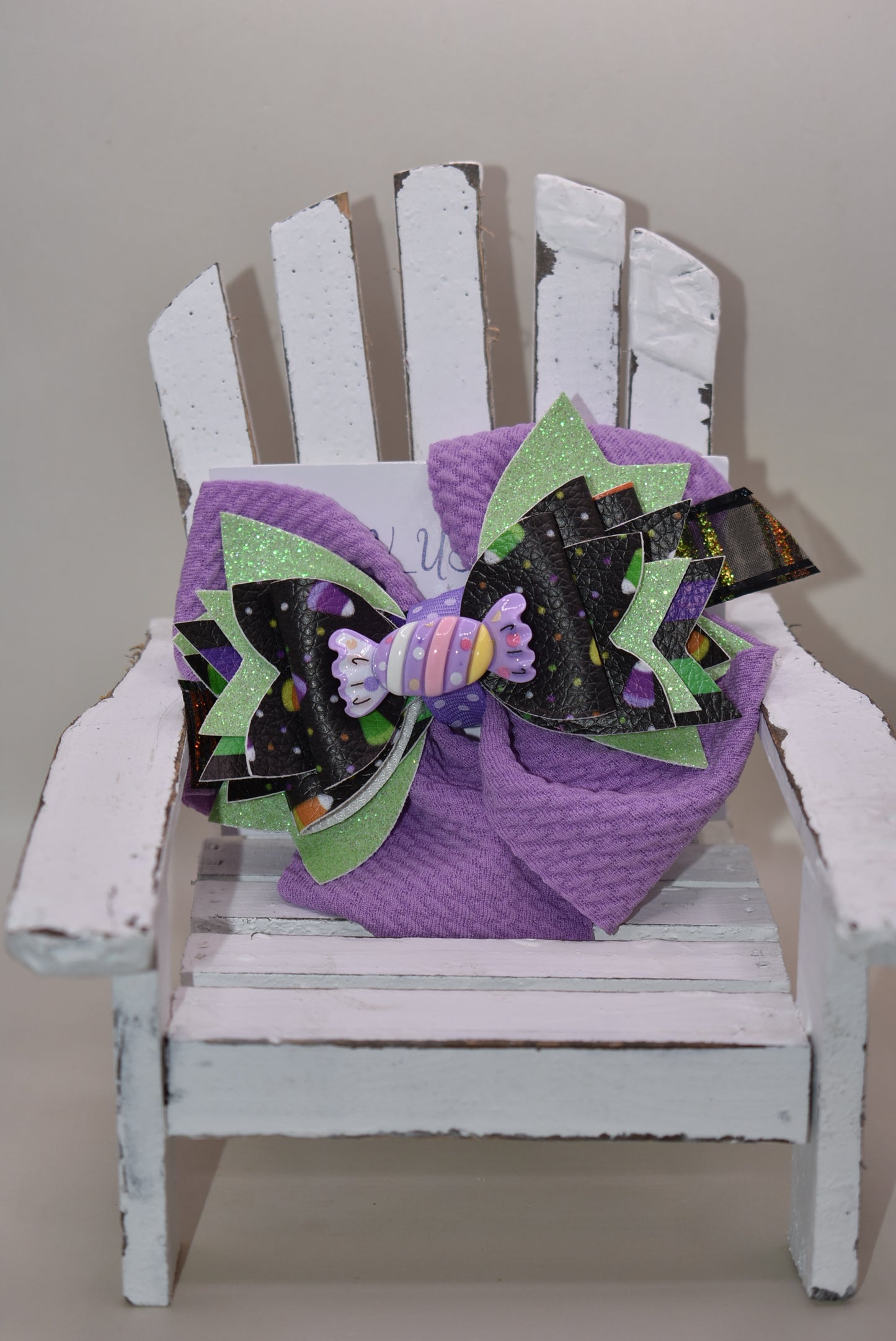 Get ready for spooky sweetness with this playful Halloween bow! 🎃 Layers of candy-inspired faux leather pop against a vibrant purple backdrop, adding a fun twist to your festive look. 🍬 Easily clip it on with a handy alligator clip for quick and comfy wear. Perfect for trick-or-treating or party fun! 🍭