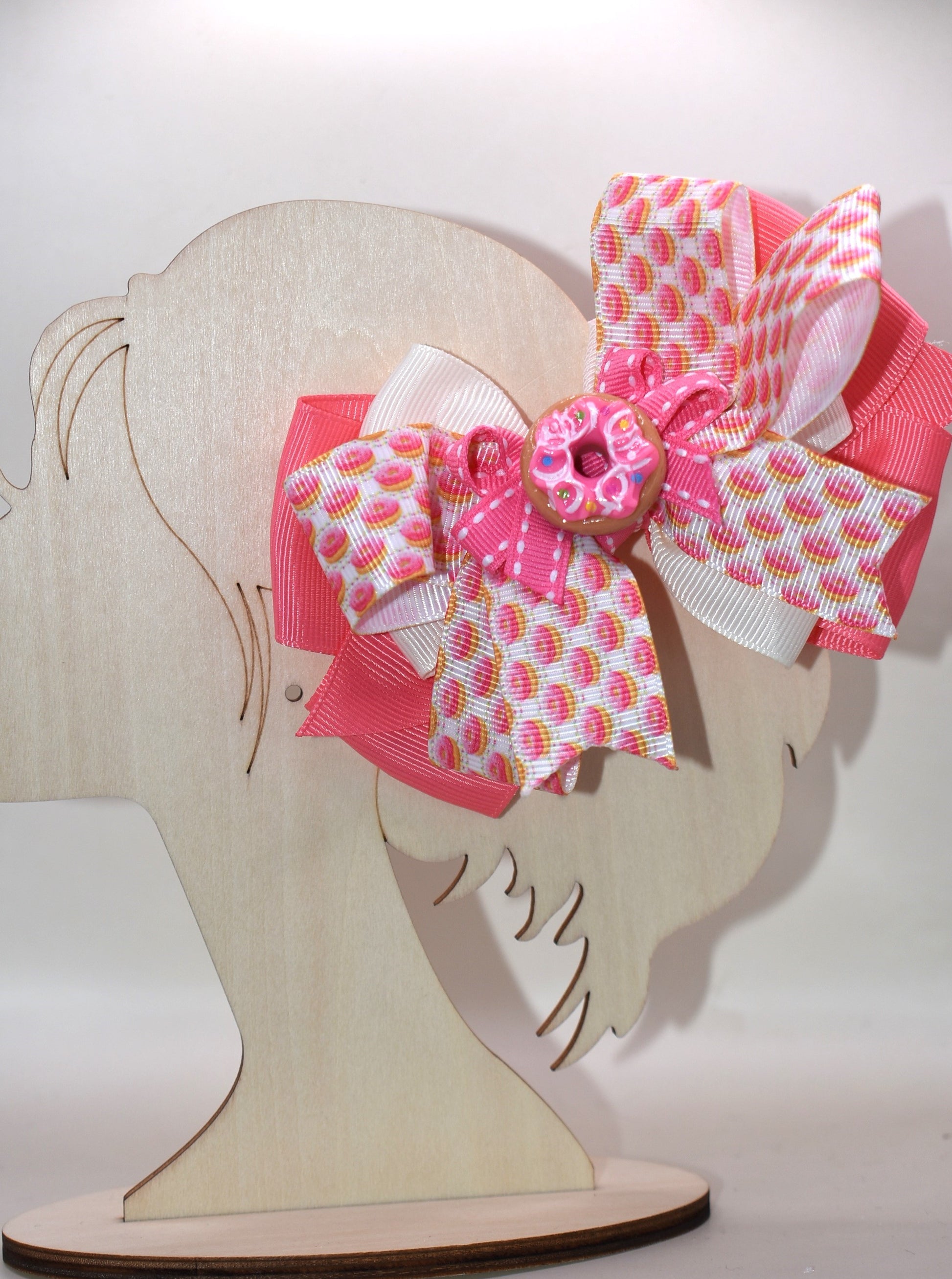Get ready to sprinkle some sweetness into your day! 🍩 This adorable donut-themed bow features vibrant pink and colorful ribbons layered with playful charm. The wrapped alligator clip on the back makes it super easy to secure in your hair, so you can rock your donut dreams from morning to night. Perfect for anyone who loves a little whimsy and wants to show off their fun side! 🎀✨
