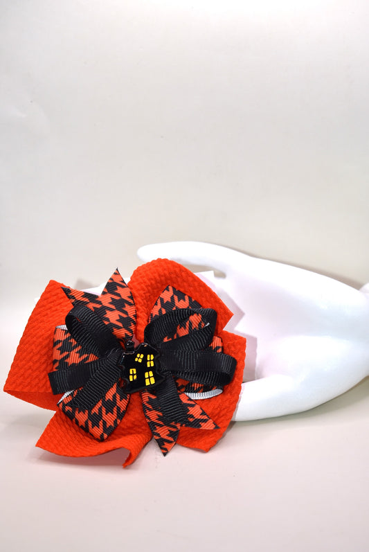 🎃 Add a spooktacular touch to your look with this Halloween Collection bow! Featuring a bold orange and black ribbon in a crazy fun pattern, it holds an adorable haunted house charm on top. The alligator clip on the back ensures a secure fit that stays put all day—perfect for any ghostly gathering! 👻🦇