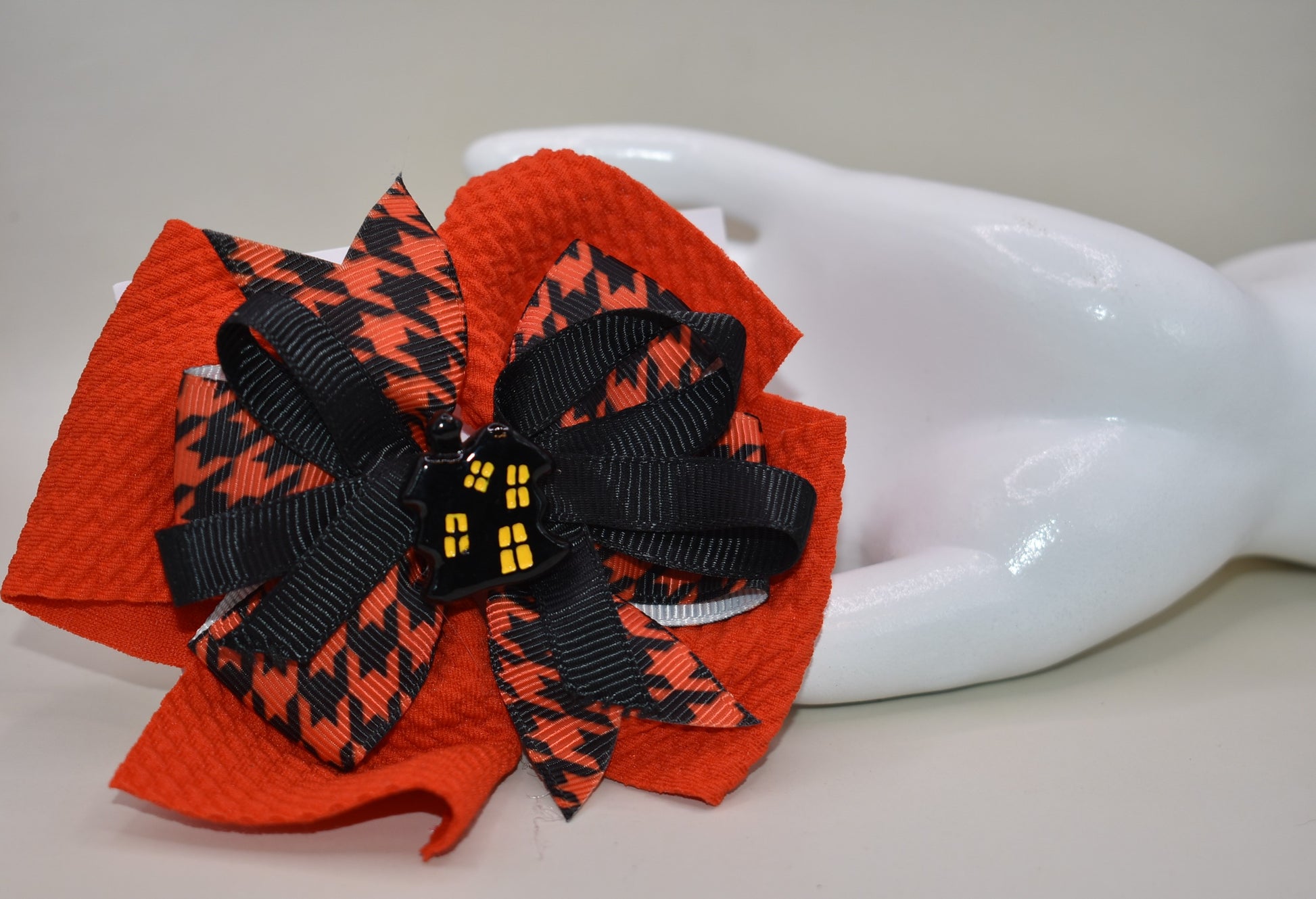 🎃 Add a spooktacular touch to your look with this Halloween Collection bow! Featuring a bold orange and black ribbon in a crazy fun pattern, it holds an adorable haunted house charm on top. The alligator clip on the back ensures a secure fit that stays put all day—perfect for any ghostly gathering! 👻🦇