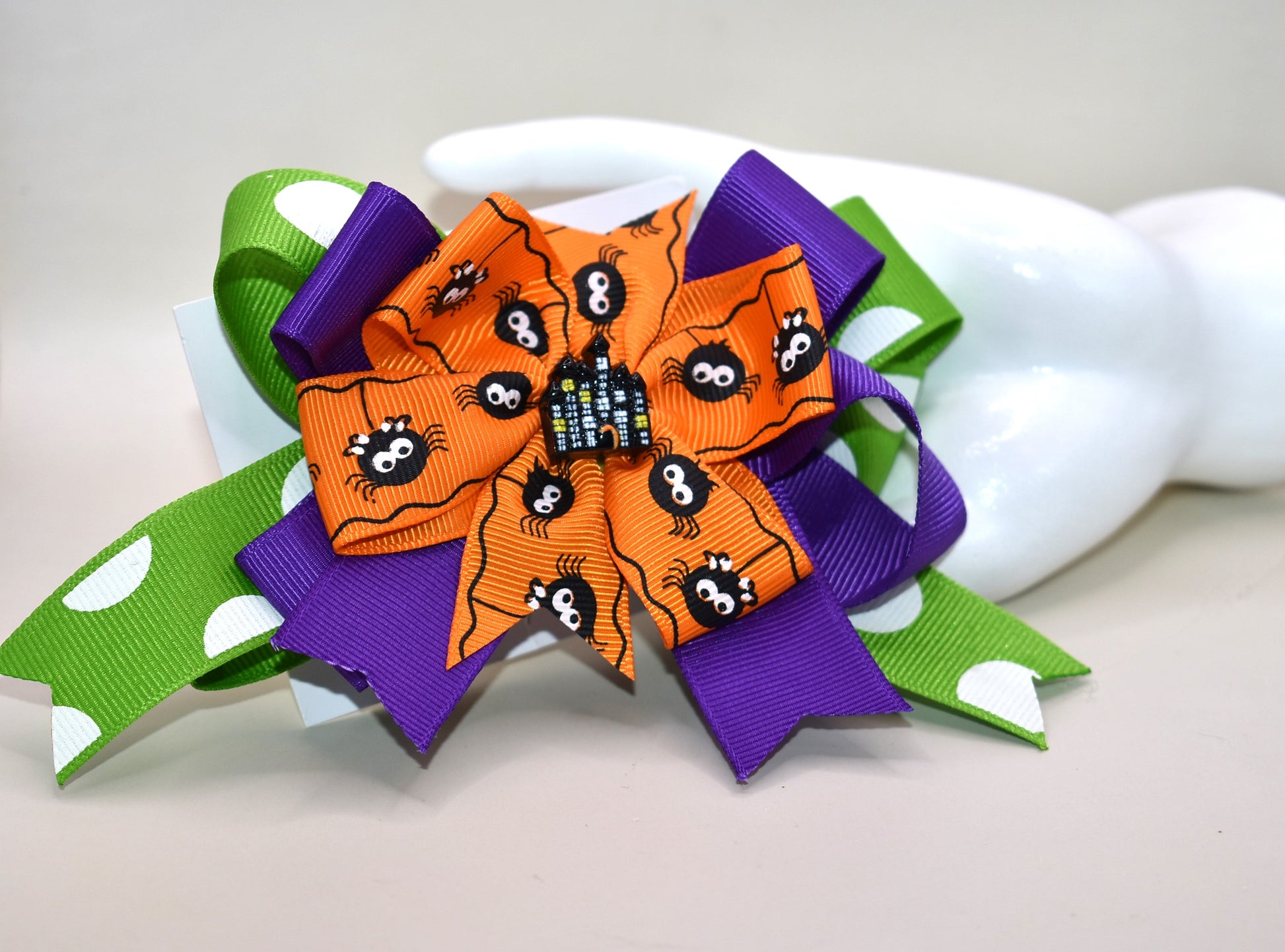 Get into the spooky spirit with this Halloween bow featuring a bold green polka dot ribbon and a charming spider ribbon 🕷️. Topped with an adorable haunted house charm 🏚️, it's the perfect festive accessory. Easy to wear with a wrapped alligator clip on the back — just clip and go! 🎃👻