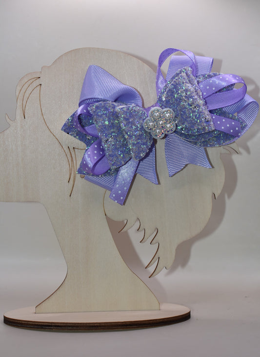 ✨ Introducing Nana's Collection – where elegance meets whimsy! 🎀 This stunning lavender bow features luxurious layers of ribbon and faux leather that create depth and dimension. A delicate flower charm sits pretty on top, adding the perfect finishing touch. 🌸 Secured with a wrapped alligator clip for effortless styling, this versatile accessory transitions seamlessly from casual to fancy. Whether you're dressing up for a special occasion or adding a pop of charm to your everyday look, this bow is your go-