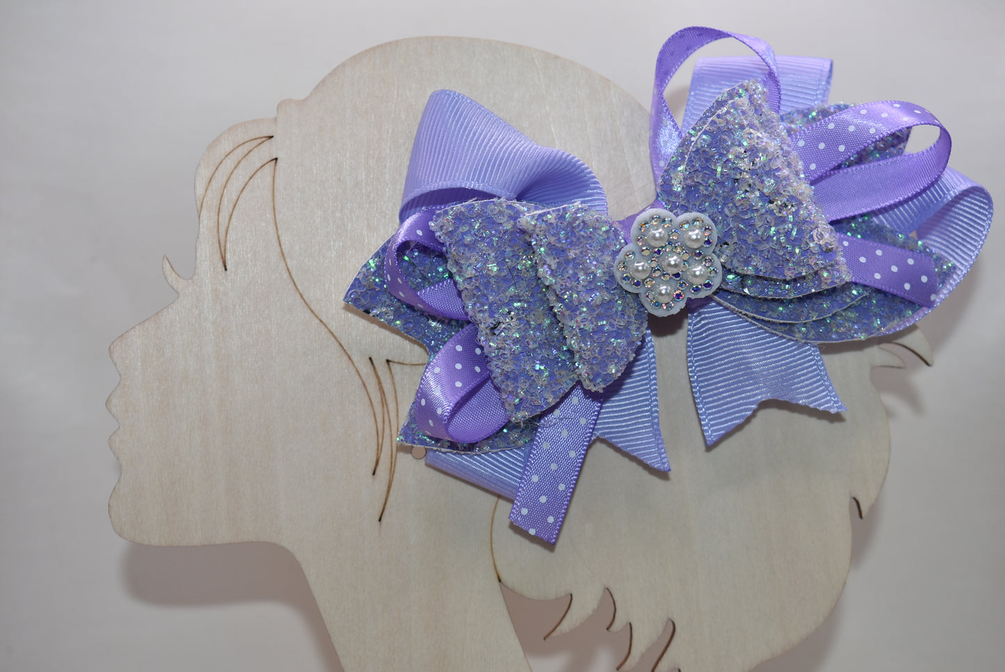 ✨ Introducing Nana's Collection – where elegance meets whimsy! 🎀 This stunning lavender bow features luxurious layers of ribbon and faux leather that create depth and dimension. A delicate flower charm sits pretty on top, adding the perfect finishing touch. 🌸 Secured with a wrapped alligator clip for effortless styling, this versatile accessory transitions seamlessly from casual to fancy. Whether you're dressing up for a special occasion or adding a pop of charm to your everyday look, this bow is your go-