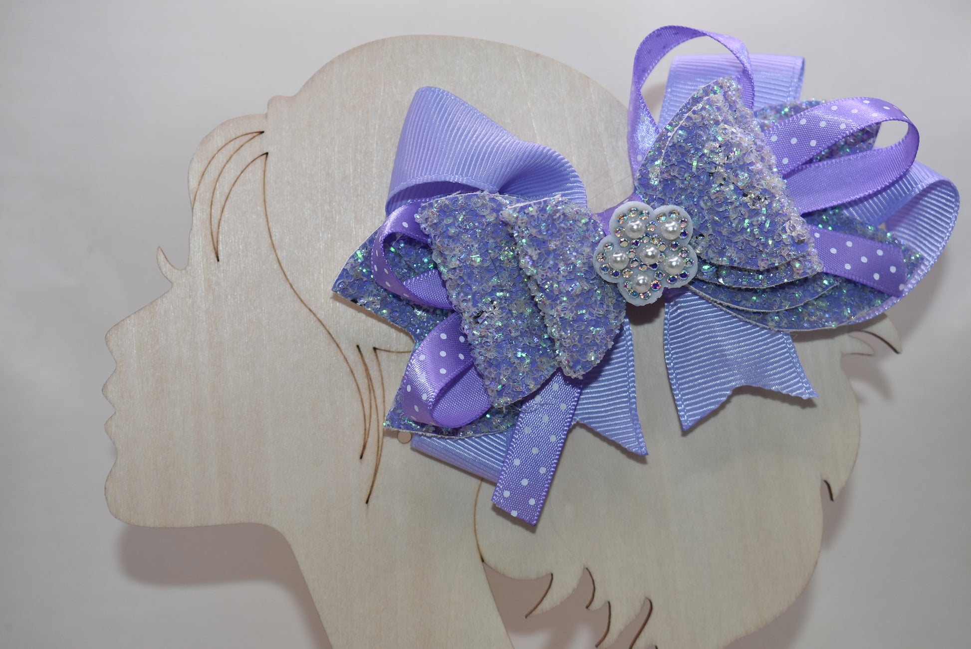 ✨ Introducing Nana's Collection – where elegance meets whimsy! 🎀 This stunning lavender bow features luxurious layers of ribbon and faux leather that create depth and dimension. A delicate flower charm sits pretty on top, adding the perfect finishing touch. 🌸 Secured with a wrapped alligator clip for effortless styling, this versatile accessory transitions seamlessly from casual to fancy. Whether you're dressing up for a special occasion or adding a pop of charm to your everyday look, this bow is your go-