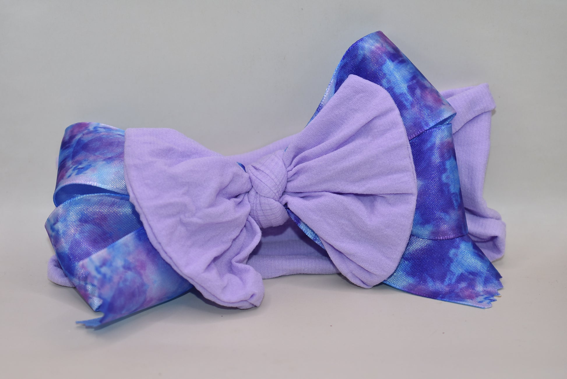 Add a splash of fun with this beautiful light purple wide headband! Featuring a pretty purple tie-dye ribbon right in the middle, it’s super soft and comfy for all-day wear. Perfect for brightening your look with a playful twist! 💜✨🎀