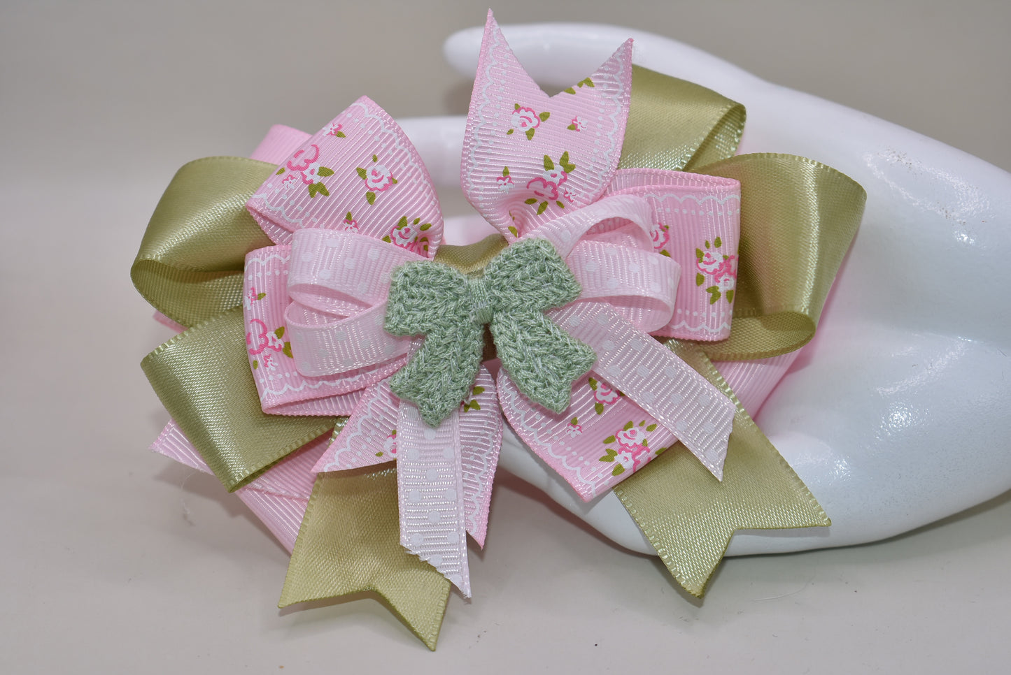 Add some fun and flair to your look with Nana's Collection 39! Featuring a playful mix of sage green and pink ribbons, topped with a cute crochet bow on a polka dot ribbon. Multiple layers of mixed ribbon make it an eye-catching accessory. Comes with a wrapped alligator clip for easy use.