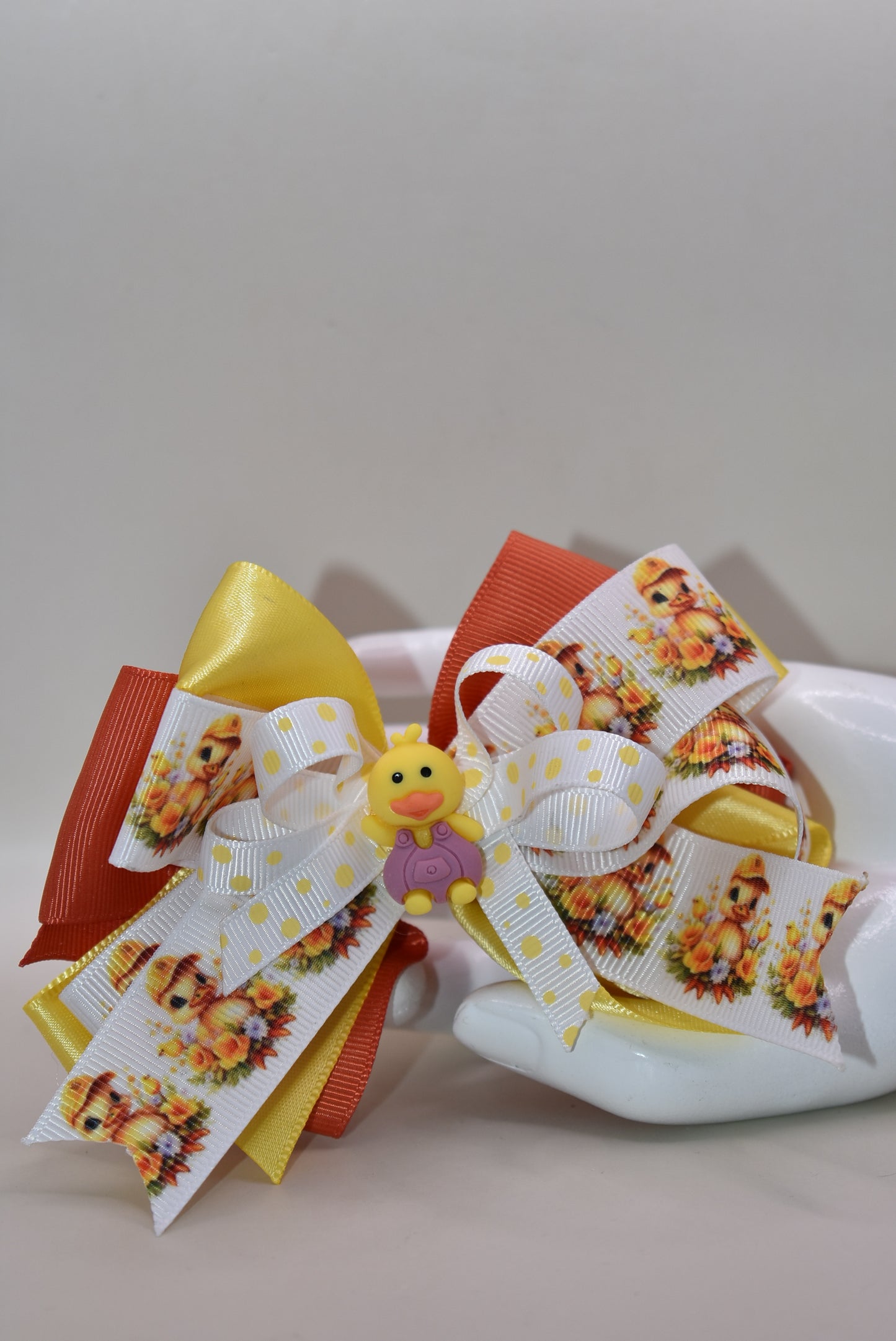 Meet your new feathered friend! 🦆 This adorable duck charm is the perfect accessory for duck enthusiasts everywhere. Perched proudly on top with cascading layers of ribbon behind it, this cutie brings charm and personality to any look. The wrapped alligator clip makes it effortless to attach and wear throughout your day. Whether you're clipping it to your bag, hair, or jacket, this delightful duck charm is sure to quack a smile! ✨🎀