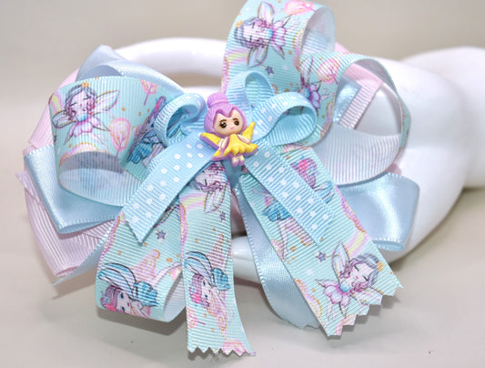 Add a touch of whimsy to any outfit with Nana's Collection 30! This darling fairy bow is made of layers of satin and grosgrain material, sure to catch the eye. Complete with a fairy ribbon and charming fairy charm, and an alligator clip for all-day comfort. Love at first sight!