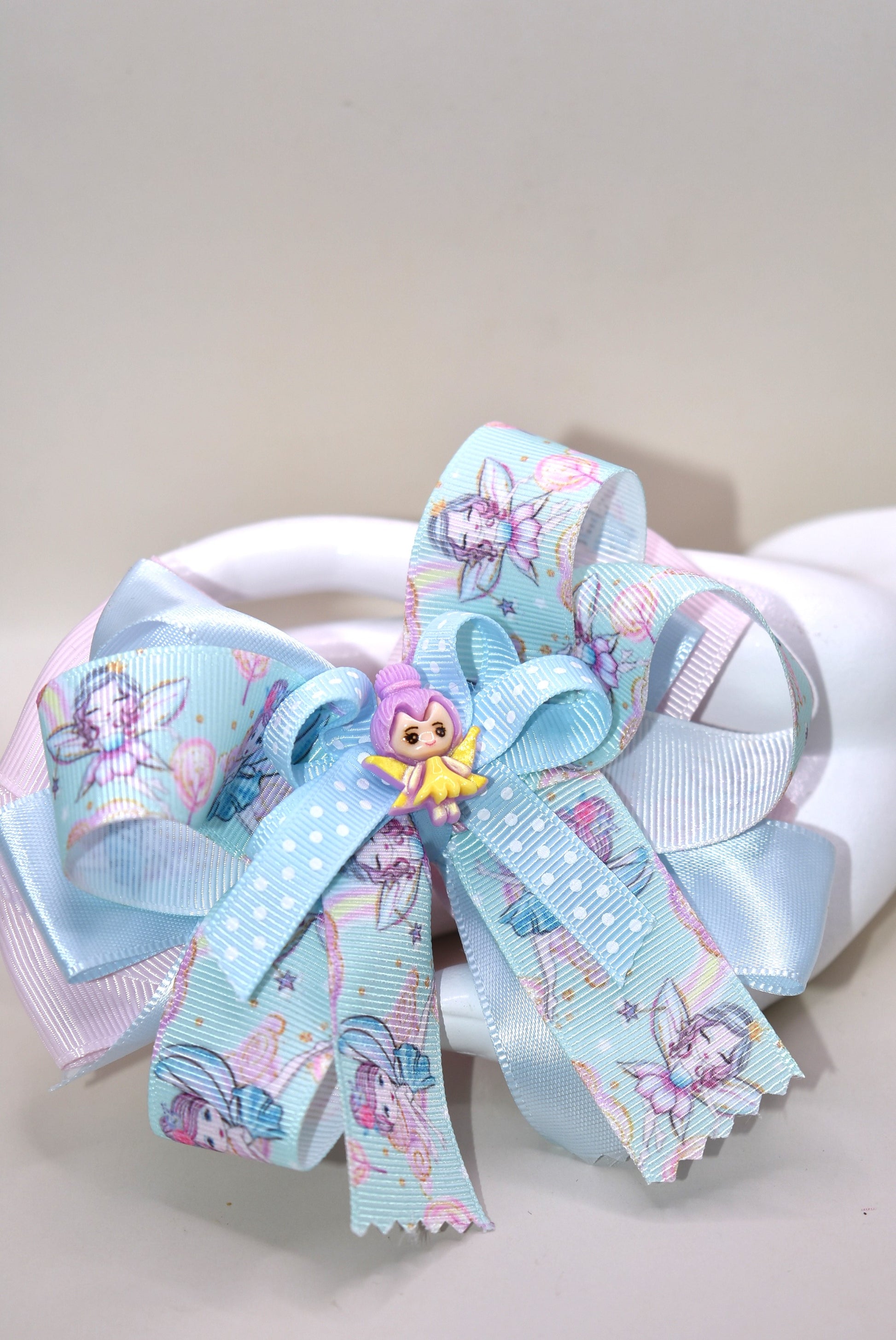 Add a touch of whimsy to any outfit with Nana's Collection 30! This darling fairy bow is made of layers of satin and grosgrain material, sure to catch the eye. Complete with a fairy ribbon and charming fairy charm, and an alligator clip for all-day comfort. Love at first sight!