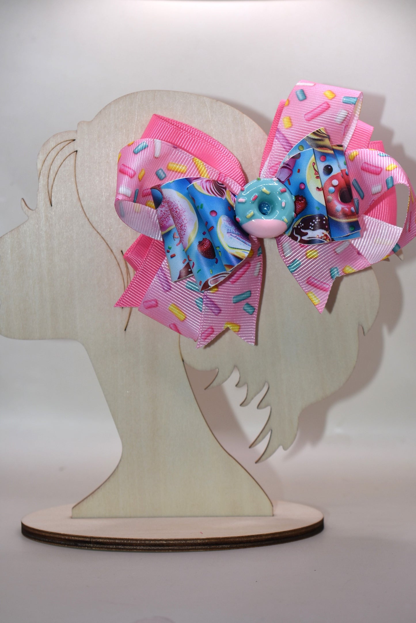 🍩 Get ready to sprinkle some sweetness into your style! This fun and colorful donut bow features layers of soft ribbon and faux leather that come together in the most adorable way. Topped with a charming donut charm, it's the perfect accessory to add a playful pop to any outfit. Whether you're dressing up for a special occasion or just want to brighten your everyday look, this delightful bow brings joy and personality to your wardrobe. 🎀✨