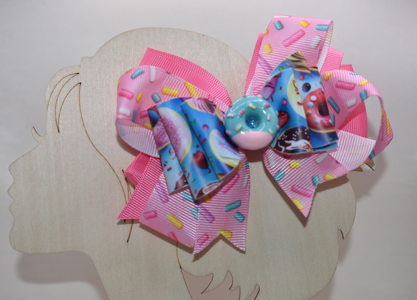 🍩 Get ready to sprinkle some sweetness into your style! This fun and colorful donut bow features layers of soft ribbon and faux leather that come together in the most adorable way. Topped with a charming donut charm, it's the perfect accessory to add a playful pop to any outfit. Whether you're dressing up for a special occasion or just want to brighten your everyday look, this delightful bow brings joy and personality to your wardrobe. 🎀✨