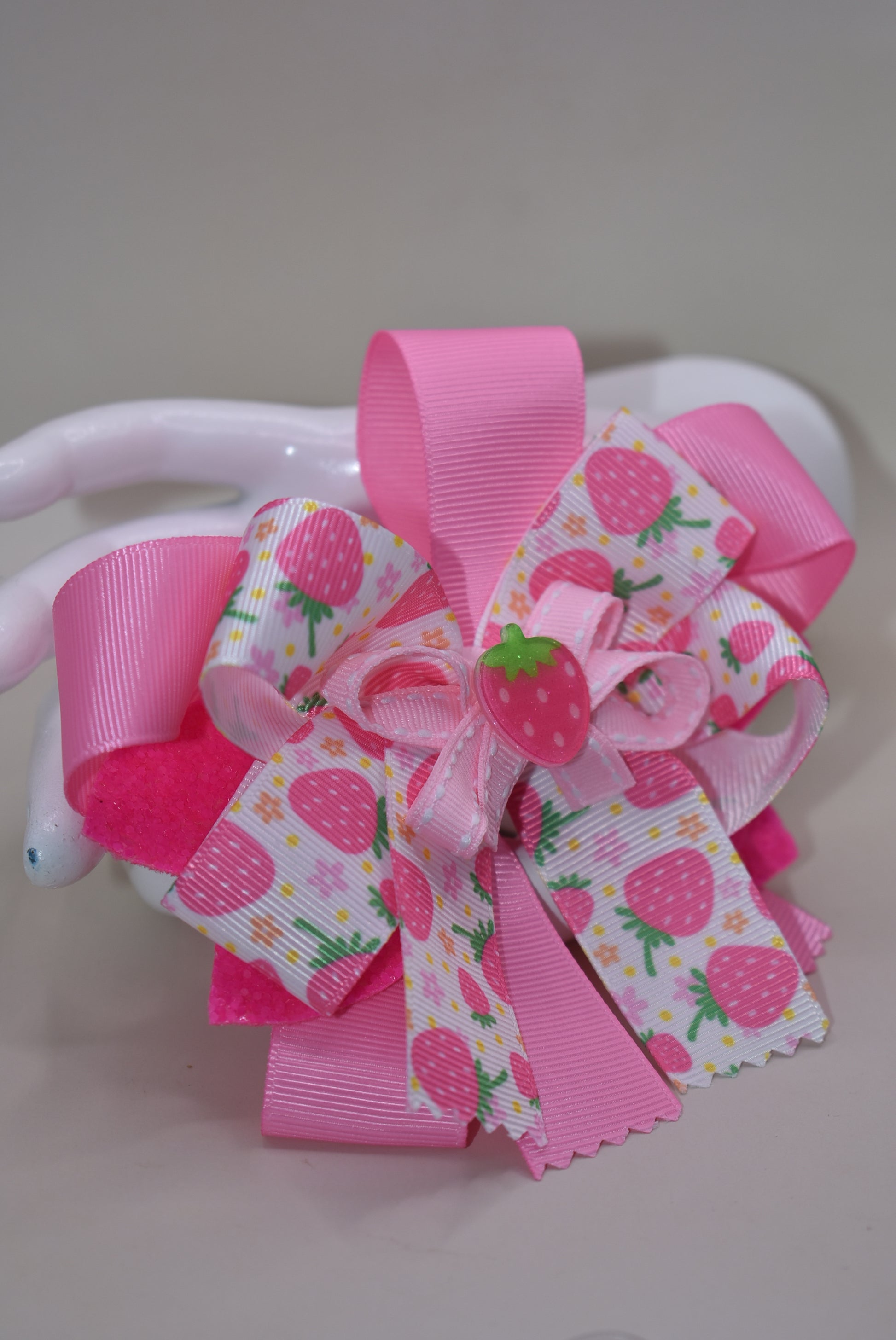 Fall in love with Nana's Collection 55! This sweet strawberry bow is perfect for summertime fun and comes with an alligator clip for a secure and comfortable fit. Your little one will be sure to adore this playful and stylish accessory.