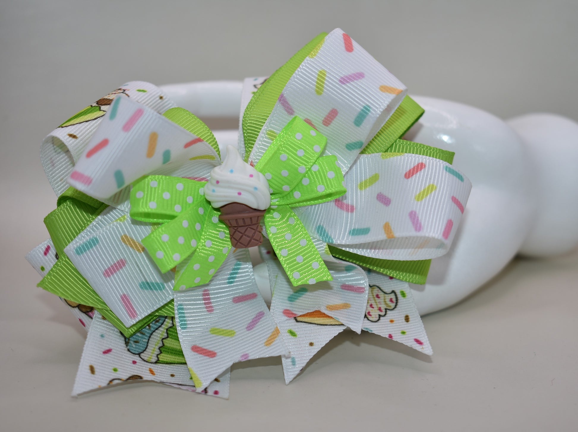 Sweet treats meet style! 🧁✨ This adorable cupcake charm features layers of fun with colorful sprinkle ribbons that bring the party wherever you go. The charming cupcake sits proudly on top, ready to brighten your day. Secured with a wrapped alligator clip, it stays put through all your adventures. Perfect for adding a sprinkle of joy to your hair! 🎀🌈