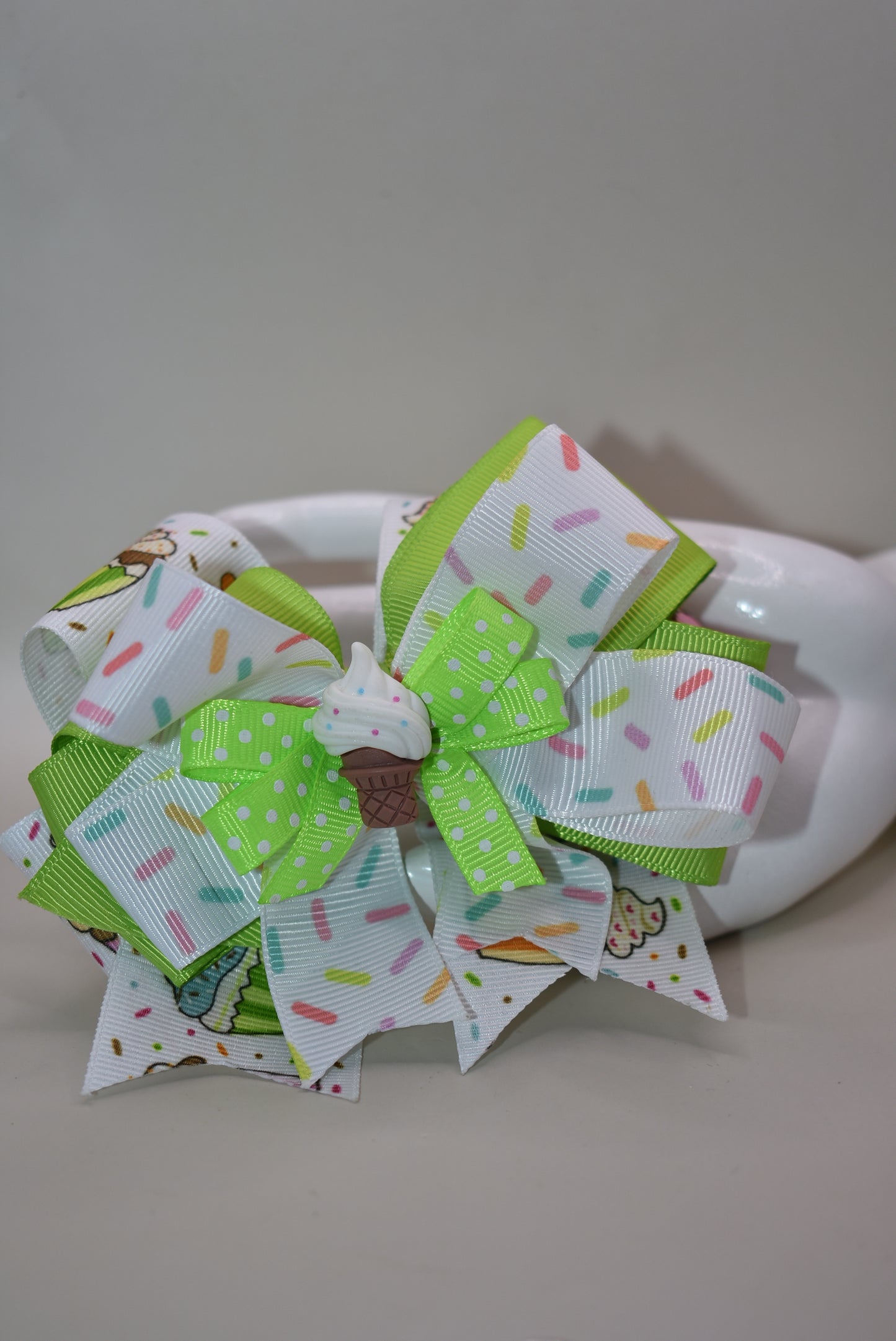Sweet treats meet style! 🧁✨ This adorable cupcake charm features layers of fun with colorful sprinkle ribbons that bring the party wherever you go. The charming cupcake sits proudly on top, ready to brighten your day. Secured with a wrapped alligator clip, it stays put through all your adventures. Perfect for adding a sprinkle of joy to your hair! 🎀🌈