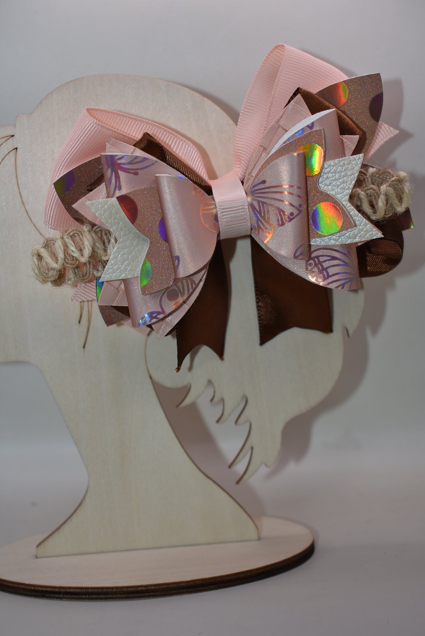Elevate your style with this gorgeous layered bow clip! 🎀 Crafted from a chic mix of faux leather and silky ribbons in warm peach and rich brown tones, it's the perfect accessory to add personality to any look. Whether you're dressing up for a special occasion or keeping it casual, this versatile beauty works with everything. 💕 The wrapped alligator clip ensures a secure, comfortable fit all day long. ✨ A must-have piece from Nana's Collection!