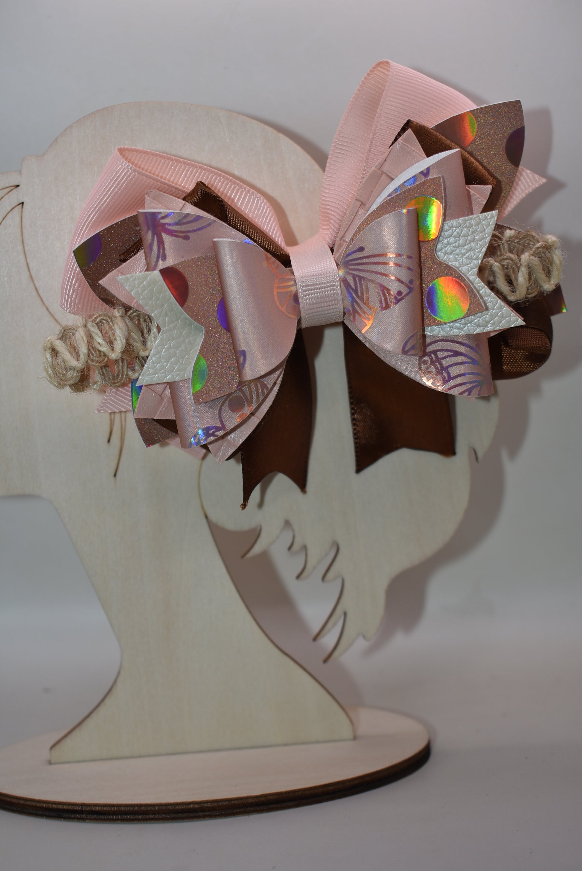 Elevate your style with this gorgeous layered bow clip! 🎀 Crafted from a chic mix of faux leather and silky ribbons in warm peach and rich brown tones, it's the perfect accessory to add personality to any look. Whether you're dressing up for a special occasion or keeping it casual, this versatile beauty works with everything. 💕 The wrapped alligator clip ensures a secure, comfortable fit all day long. ✨ A must-have piece from Nana's Collection!