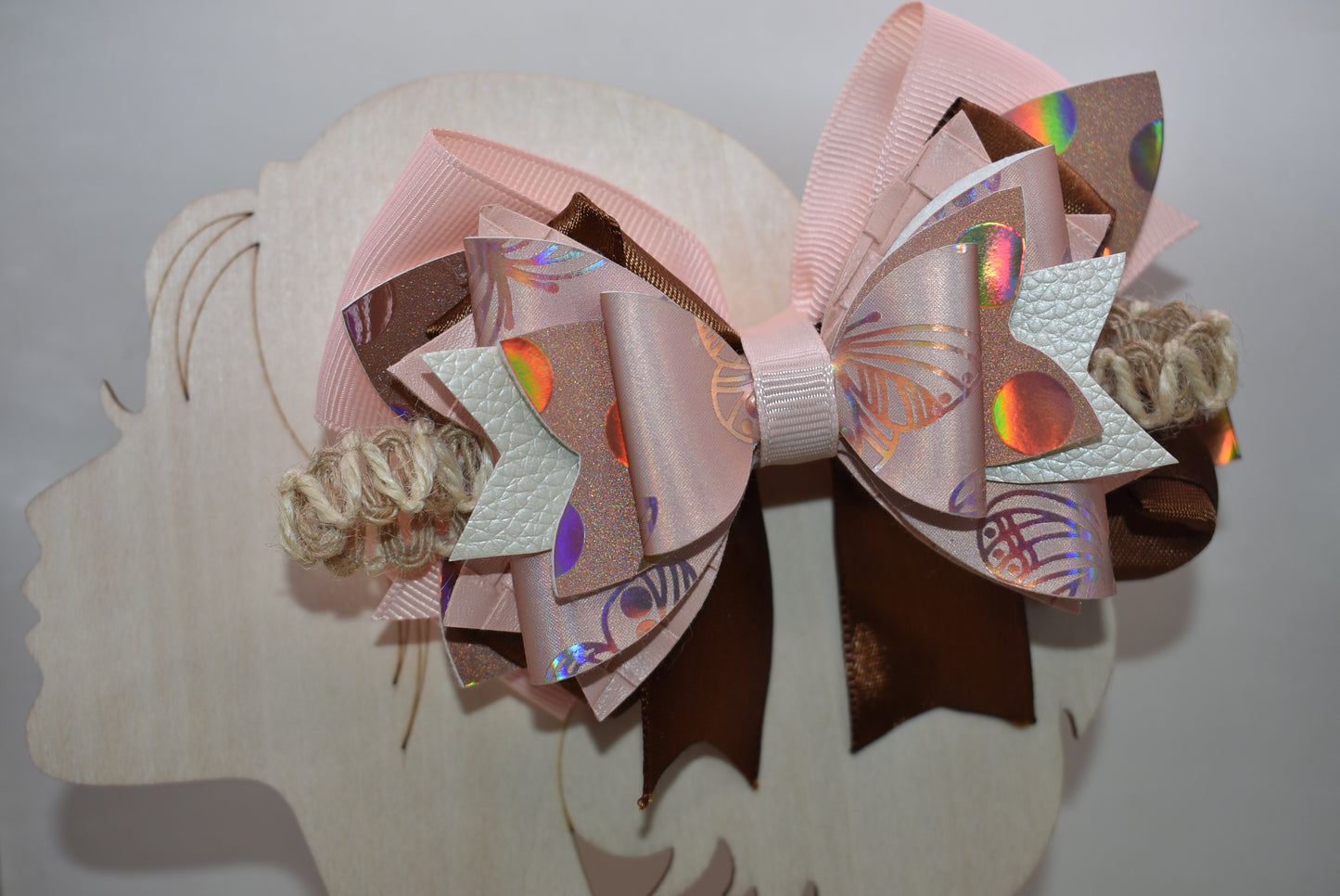 Elevate your style with this gorgeous layered bow clip! 🎀 Crafted from a chic mix of faux leather and silky ribbons in warm peach and rich brown tones, it's the perfect accessory to add personality to any look. Whether you're dressing up for a special occasion or keeping it casual, this versatile beauty works with everything. 💕 The wrapped alligator clip ensures a secure, comfortable fit all day long. ✨ A must-have piece from Nana's Collection!