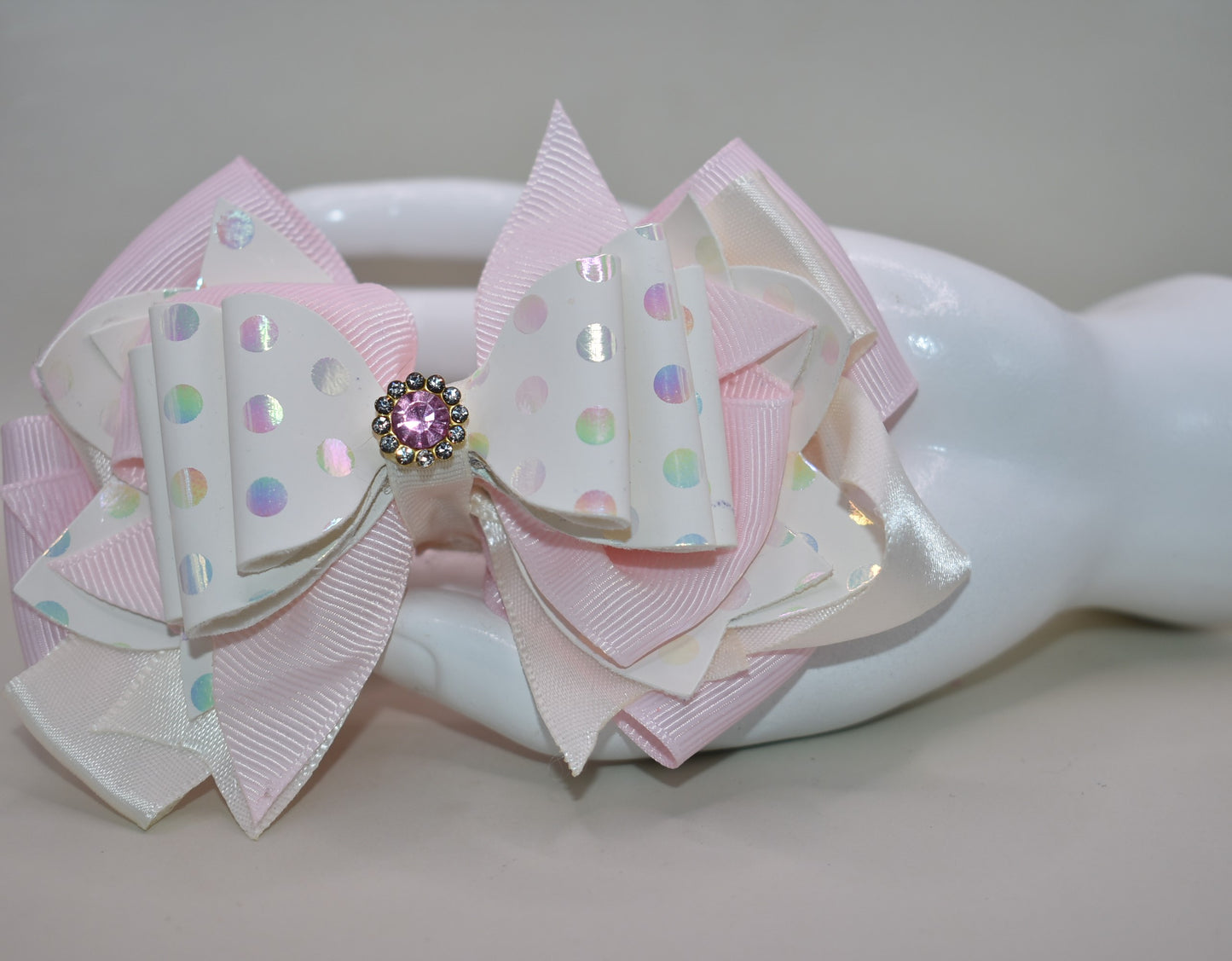 ✨ Introducing the prettiest pink bow that'll make any little girl's heart skip a beat! 💕 This adorable accessory features layers upon layers of luxurious ribbon and faux leather, creating a dimensional look that's absolutely stunning. Whether you're dressing up for a special occasion or adding a touch of charm to everyday wear, this versatile bow does it all. 👑 The sparkling crystal charm perched on top adds that extra dash of magic and elegance. Each piece is truly one-of-a-kind, making it a special trea