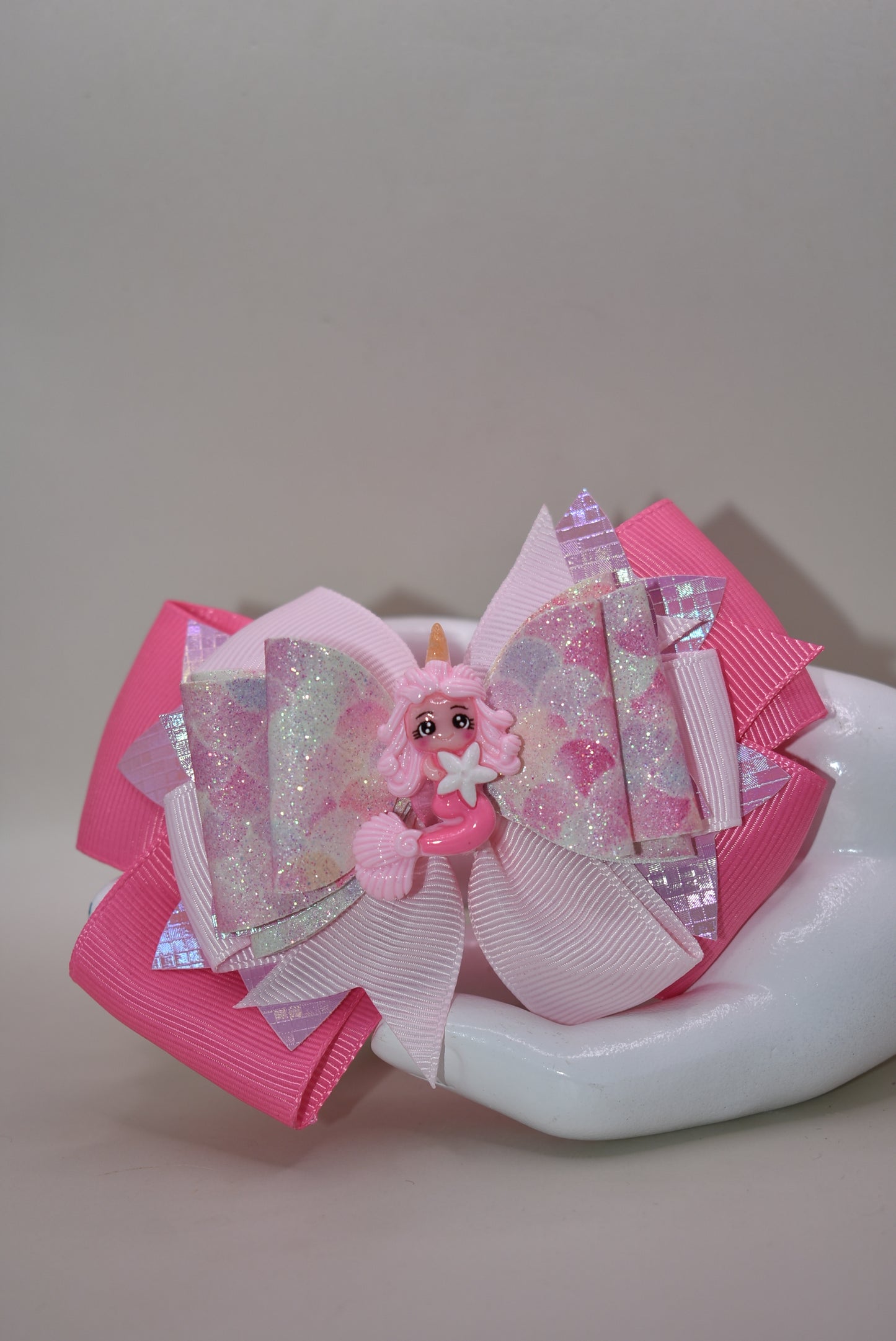 Dive into whimsy with this enchanting mermaid bow! 🧜♀️✨ Featuring layers of luxe faux leather and silky ribbon, this playful accessory is topped with an adorable pink mermaid charm that brings ocean magic to any hairstyle. The covered alligator clip ensures all-day comfort without slipping, making it perfect for little mermaids everywhere. 🎀💕 A splash of charm that's as sweet as the sea!