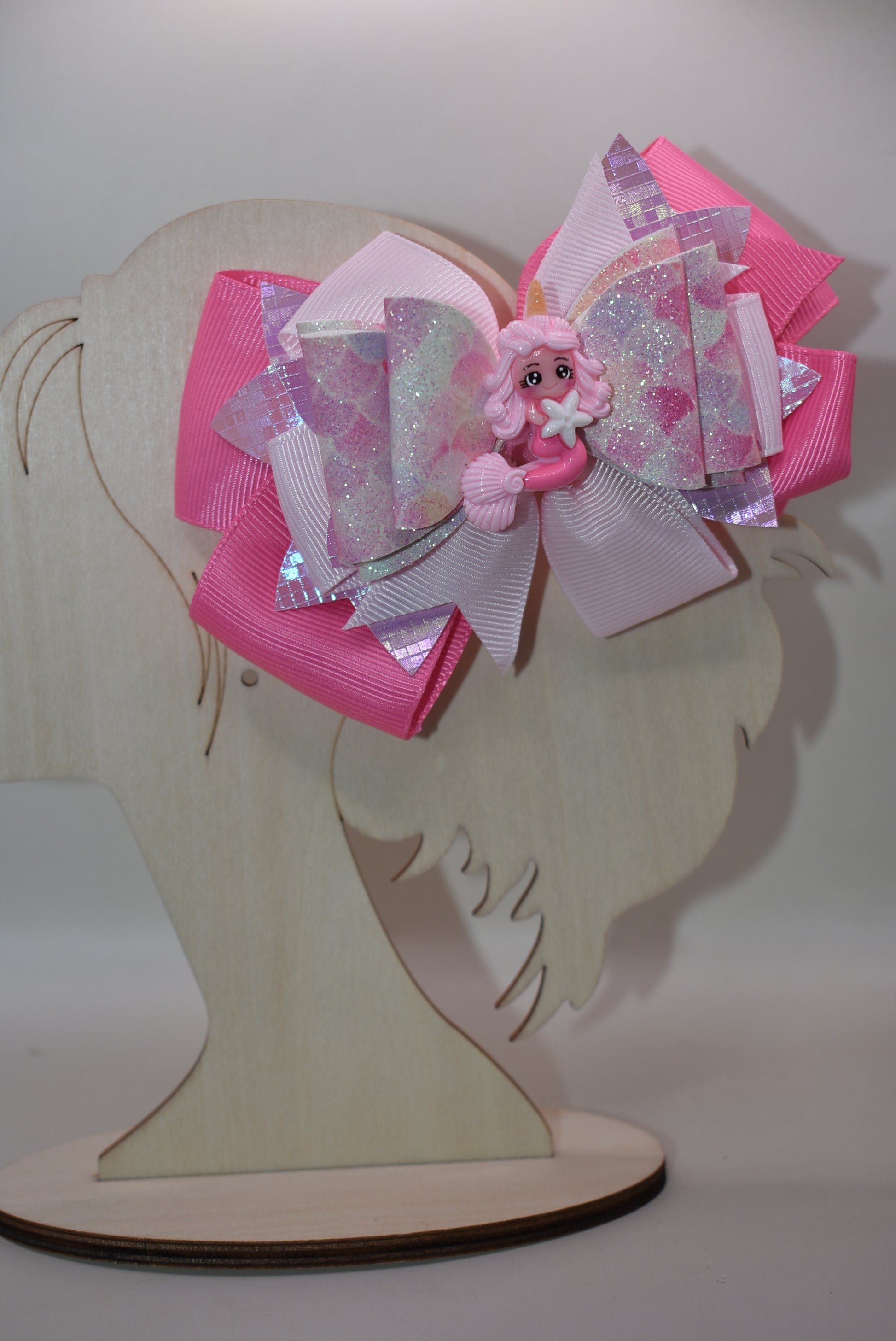 Dive into whimsy with this enchanting mermaid bow! 🧜♀️✨ Featuring layers of luxe faux leather and silky ribbon, this playful accessory is topped with an adorable pink mermaid charm that brings ocean magic to any hairstyle. The covered alligator clip ensures all-day comfort without slipping, making it perfect for little mermaids everywhere. 🎀💕 A splash of charm that's as sweet as the sea!