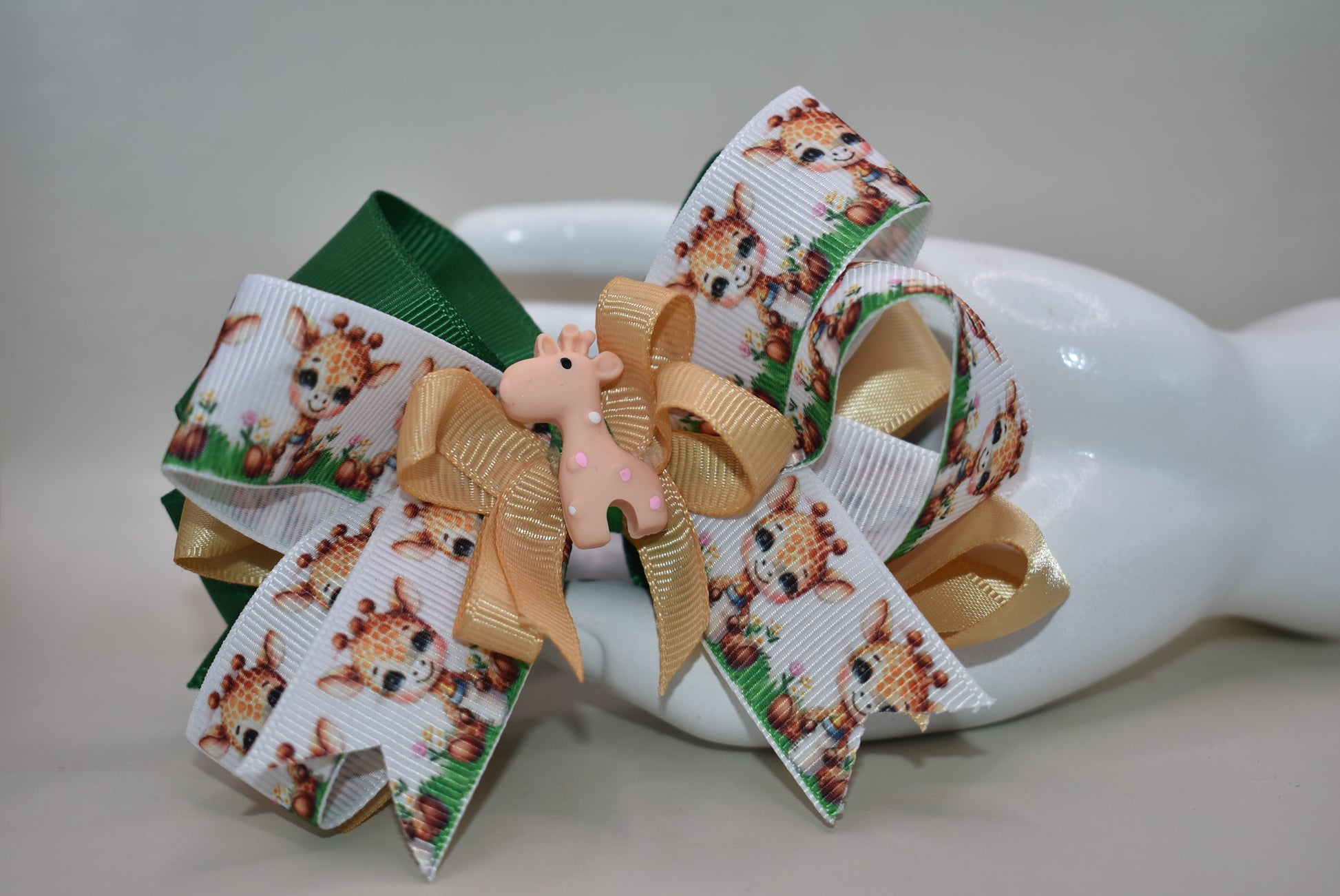 Meet your new favorite hair accessory! 🦒 This adorable giraffe bow features layered ribbons in charming giraffe print mixed with a complementary color for extra visual appeal. A precious giraffe charm sits proudly on top, adding that perfect finishing touch. The wrapped alligator clip on the back makes it super easy to secure in place, so your little one can rock this cute look all day long. Perfect for adding a splash of personality to any hairstyle! ✨🎀
