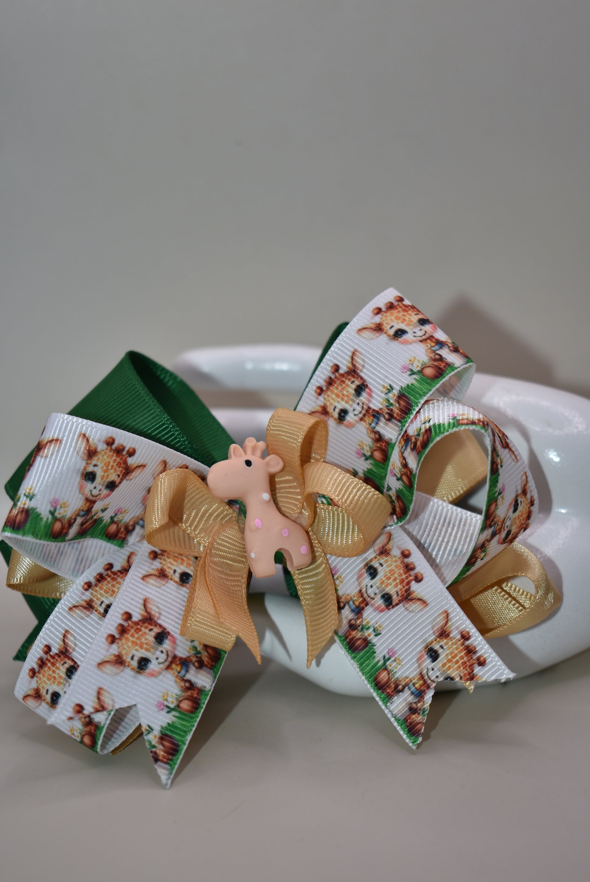Meet your new favorite hair accessory! 🦒 This adorable giraffe bow features layered ribbons in charming giraffe print mixed with a complementary color for extra visual appeal. A precious giraffe charm sits proudly on top, adding that perfect finishing touch. The wrapped alligator clip on the back makes it super easy to secure in place, so your little one can rock this cute look all day long. Perfect for adding a splash of personality to any hairstyle! ✨🎀