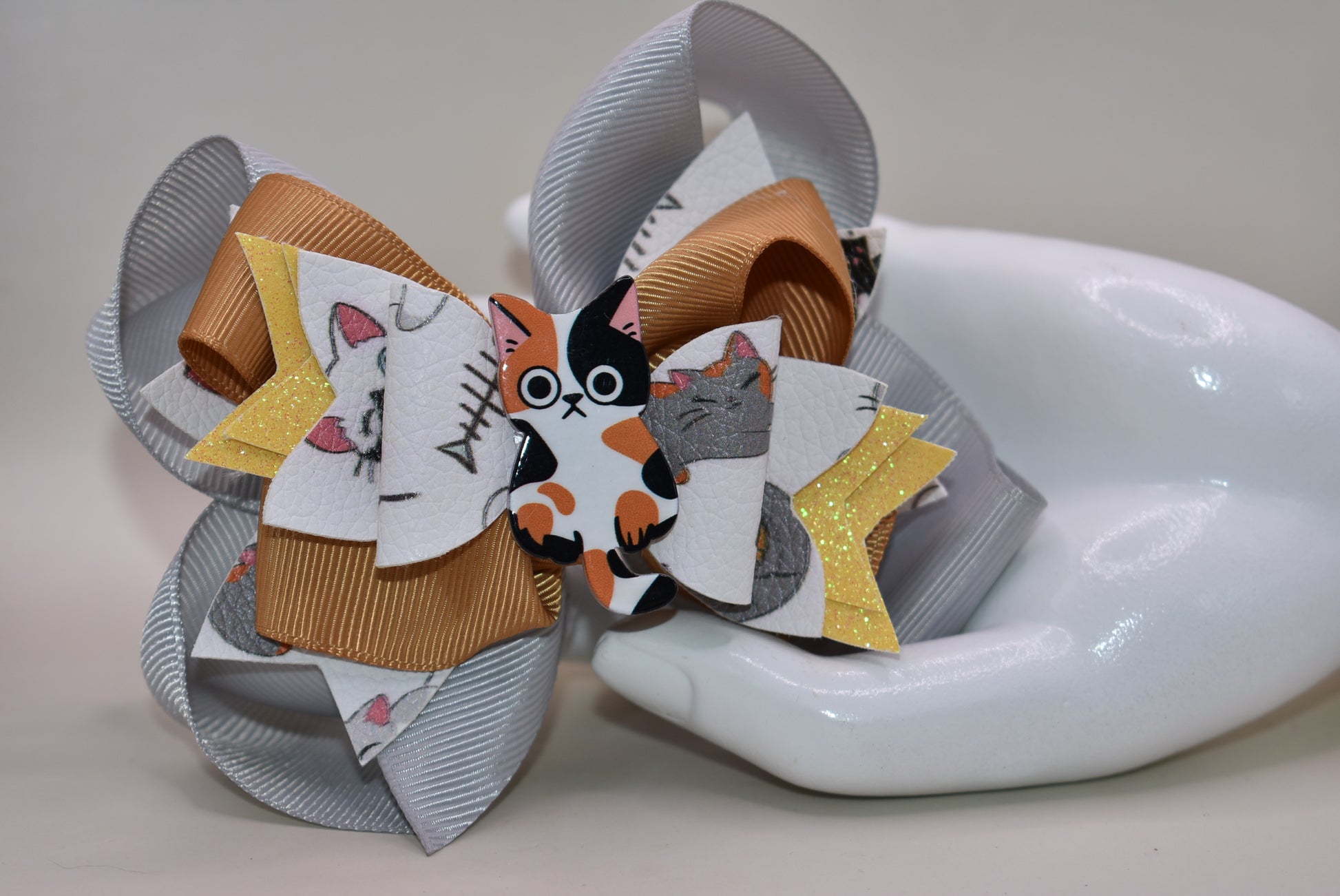 Calling all cat enthusiasts! 🐱 This adorable bow features vibrant cat print faux leather layered with charming ribbon details, topped with an irresistible calico cat charm. 😻 The wrapped alligator clip makes it effortless to secure in your hair, so you can show off your feline love all day long. Purrfect for cat lovers who want to add a playful touch to their style! 🎀