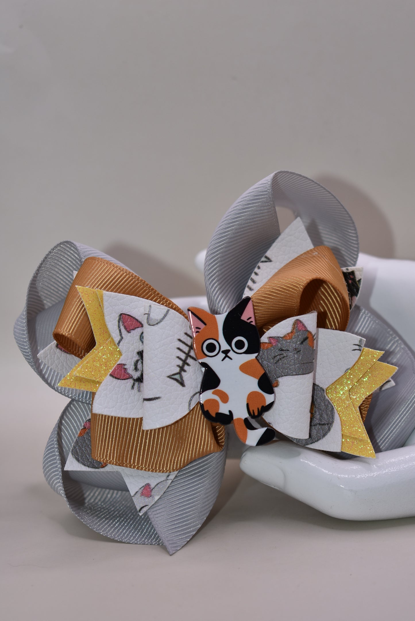 Calling all cat enthusiasts! 🐱 This adorable bow features vibrant cat print faux leather layered with charming ribbon details, topped with an irresistible calico cat charm. 😻 The wrapped alligator clip makes it effortless to secure in your hair, so you can show off your feline love all day long. Purrfect for cat lovers who want to add a playful touch to their style! 🎀