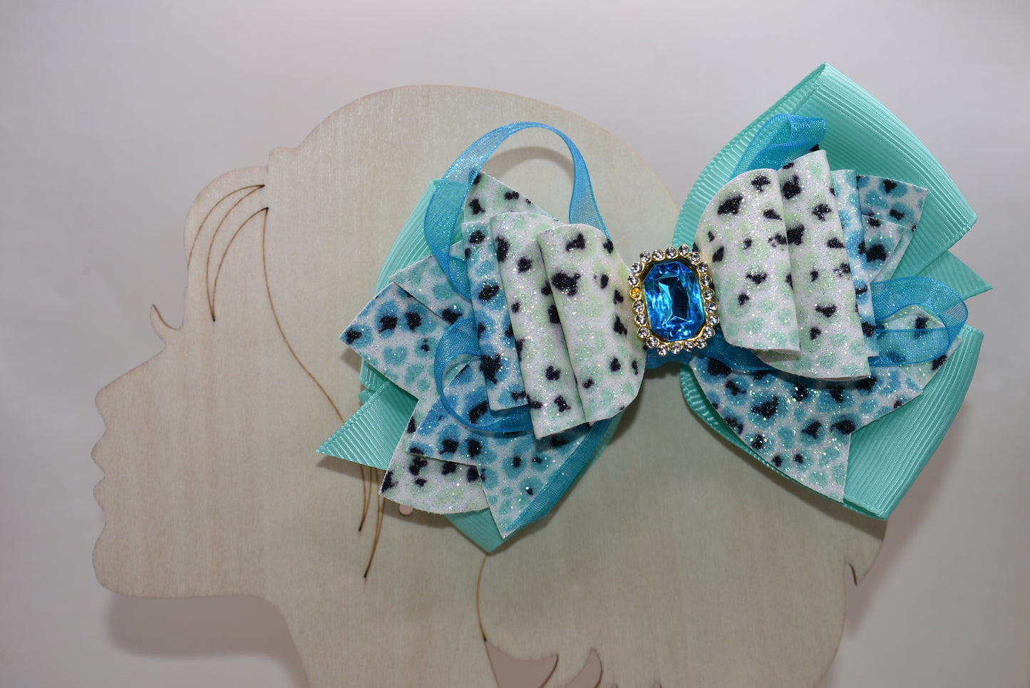 Get ready to roar! 🐆 This fabulous leopard print hair clip features multi-layered ribbon and faux leather details that bring serious style to your look. The wrapped alligator clip on back makes it super easy to secure your hair in place, while a gorgeous aqua gem sparkles on top for that perfect pop of fun. ✨ Time to unleash your wild side! 💎