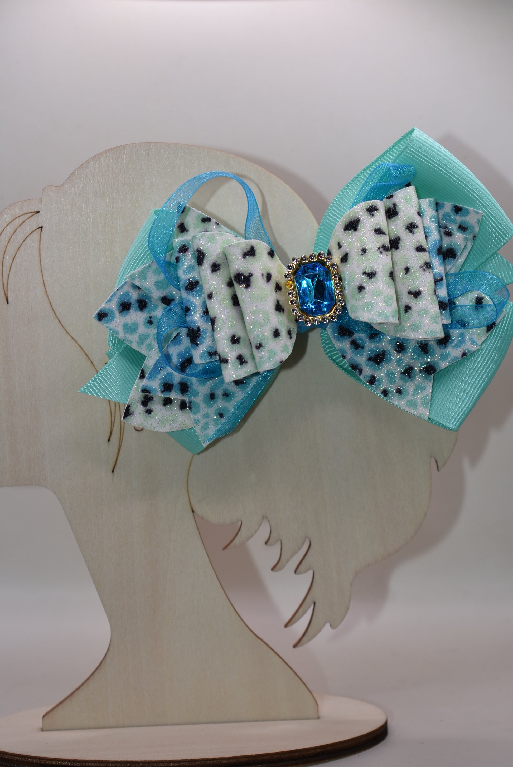 Get ready to roar! 🐆 This fabulous leopard print hair clip features multi-layered ribbon and faux leather details that bring serious style to your look. The wrapped alligator clip on back makes it super easy to secure your hair in place, while a gorgeous aqua gem sparkles on top for that perfect pop of fun. ✨ Time to unleash your wild side! 💎