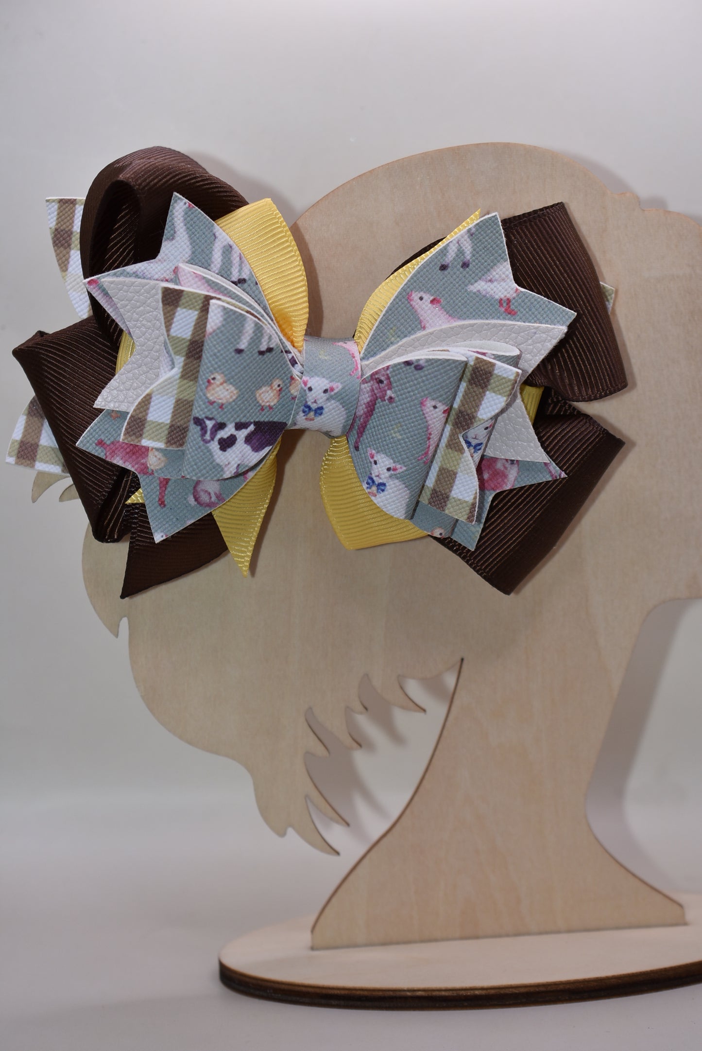Meet the bow that'll have every farmer grinning from ear to ear! 🌾 This adorable one-of-a-kind animal-themed bow is bursting with personality, featuring layers upon layers of luxe ribbon and faux leather that create serious style depth. 🎀 Whether you're heading to the barn, a country event, or just want to add a touch of whimsy to your everyday look, this charming accessory transforms any outfit into something special. 🐄✨ Nana's Collection brings that perfect blend of cute and quirky that makes you smile