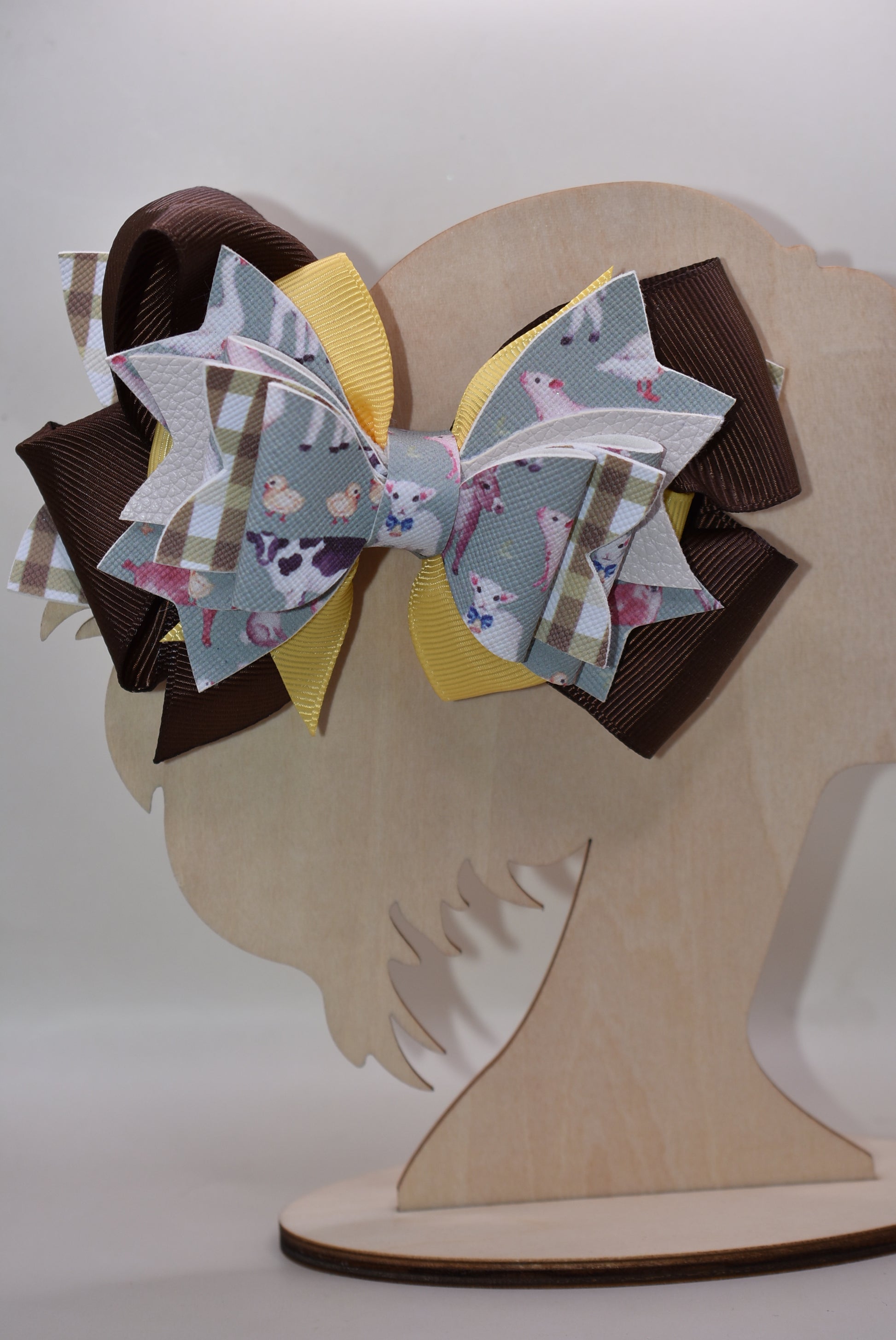 Meet the bow that'll have every farmer grinning from ear to ear! 🌾 This adorable one-of-a-kind animal-themed bow is bursting with personality, featuring layers upon layers of luxe ribbon and faux leather that create serious style depth. 🎀 Whether you're heading to the barn, a country event, or just want to add a touch of whimsy to your everyday look, this charming accessory transforms any outfit into something special. 🐄✨ Nana's Collection brings that perfect blend of cute and quirky that makes you smile
