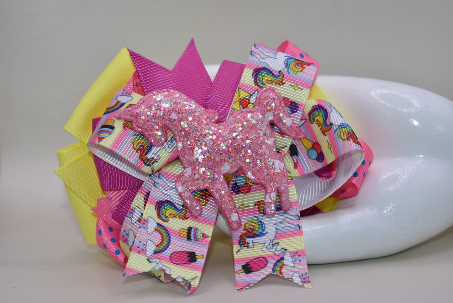 ✨ Meet your new favorite hair accessory! This one-of-a-kind bow features a gorgeous glitter unicorn figure crowned with unicorn rainbow ribbon. 🦄 Layers upon layers of vibrant, multi-colored ribbons create a whimsical masterpiece that's sure to turn heads. The secure alligator clip keeps your style in place all day long, so you can sparkle and shine from sunrise to sunset. 🎀💫 Pure magic for unicorn lovers everywhere!
