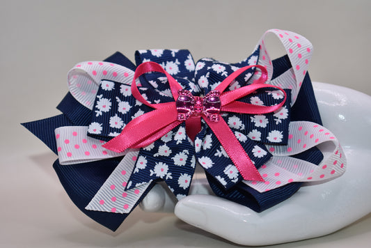 This adorable bow clip is a playful mix of navy blue and bright pink with layered textures featuring solid, floral, and polka dot patterns. 🎀 The cutest hot pink bow charm sits proudly on top, adding that extra pop of personality! ✨ Secured with a wrapped alligator clip, it stays put through all your adventures. Perfect for adding a fun, charming touch to any hairstyle! 💕