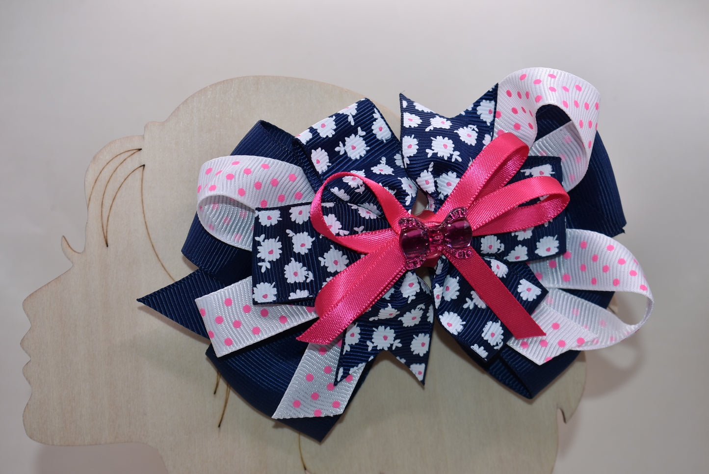 This adorable bow clip is a playful mix of navy blue and bright pink with layered textures featuring solid, floral, and polka dot patterns. 🎀 The cutest hot pink bow charm sits proudly on top, adding that extra pop of personality! ✨ Secured with a wrapped alligator clip, it stays put through all your adventures. Perfect for adding a fun, charming touch to any hairstyle! 💕
