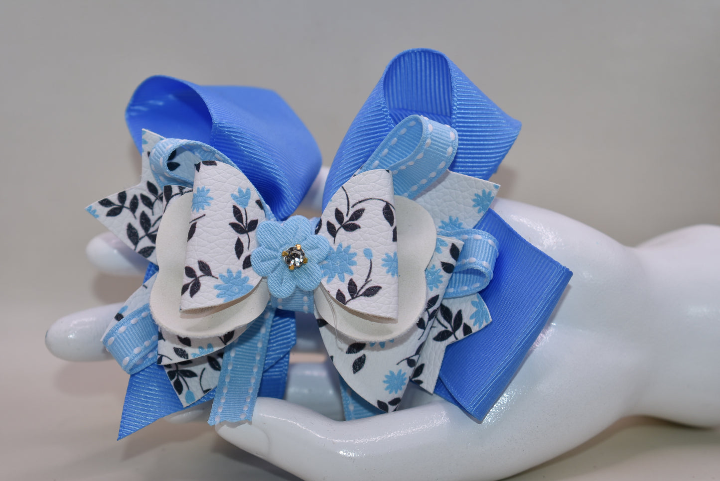 ✨ Get ready to turn heads with this stunning blue beauty! 💙 Nana's Collection 68 features gorgeous layers of ribbon and faux leather that create incredible depth and dimension. The delicate flower motif adds a touch of elegance, while the wrapped alligator clip keeps everything secure and stylish. Whether you're dressing up for a special occasion or adding flair to your everyday look, this charming accessory is the perfect finishing touch for any outfit. 🌸