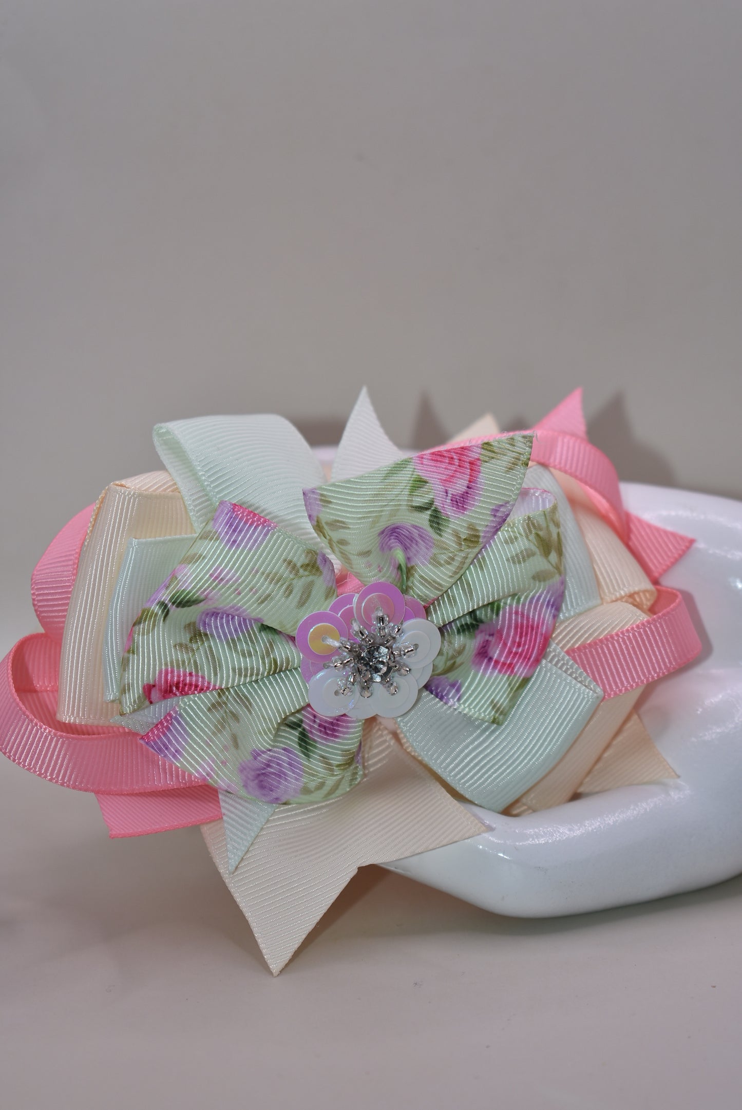 This charming bow brings springtime magic to any hairstyle! 🌸 Soft pastel pink and green hues create a dreamy aesthetic, while an adorable floral design with a sparkling crystal arrow detail catches the light beautifully throughout the day. ✨ The convenient alligator clip makes it effortless to secure, perfect for adding a touch of whimsy to your look. 🎀 Ideal for anyone who loves sweet, feminine accessories with a playful twist! 💚💗