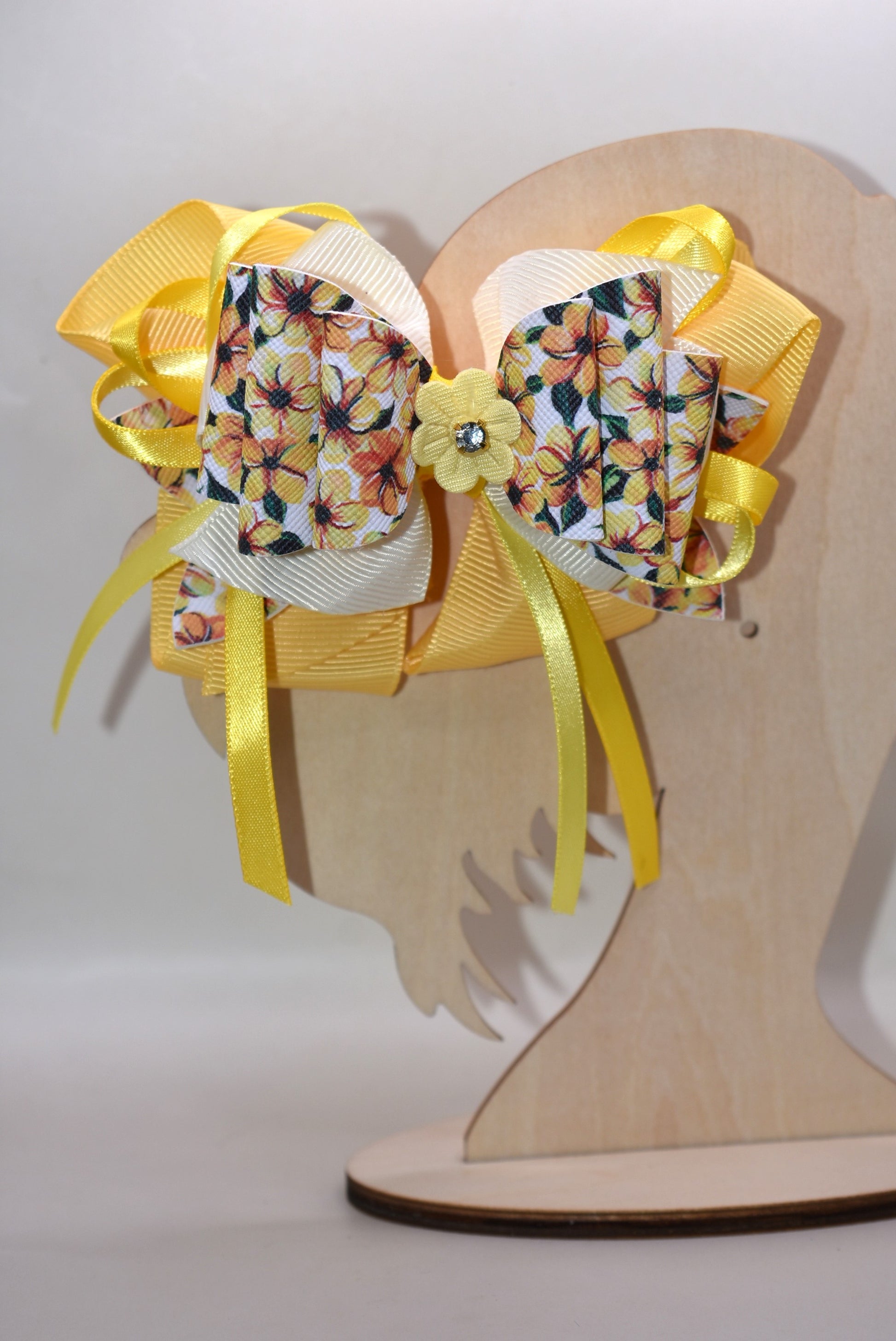 Get ready to turn heads with this vibrant yellow floral bow! 🌼 Layered ribbons and faux leather create gorgeous dimension, while a delicate yellow flower topped with a sparkling crystal adds the perfect finishing touch. ✨ The secure alligator clip keeps your style locked in place all day long. Pure joy in bow form! 💛
