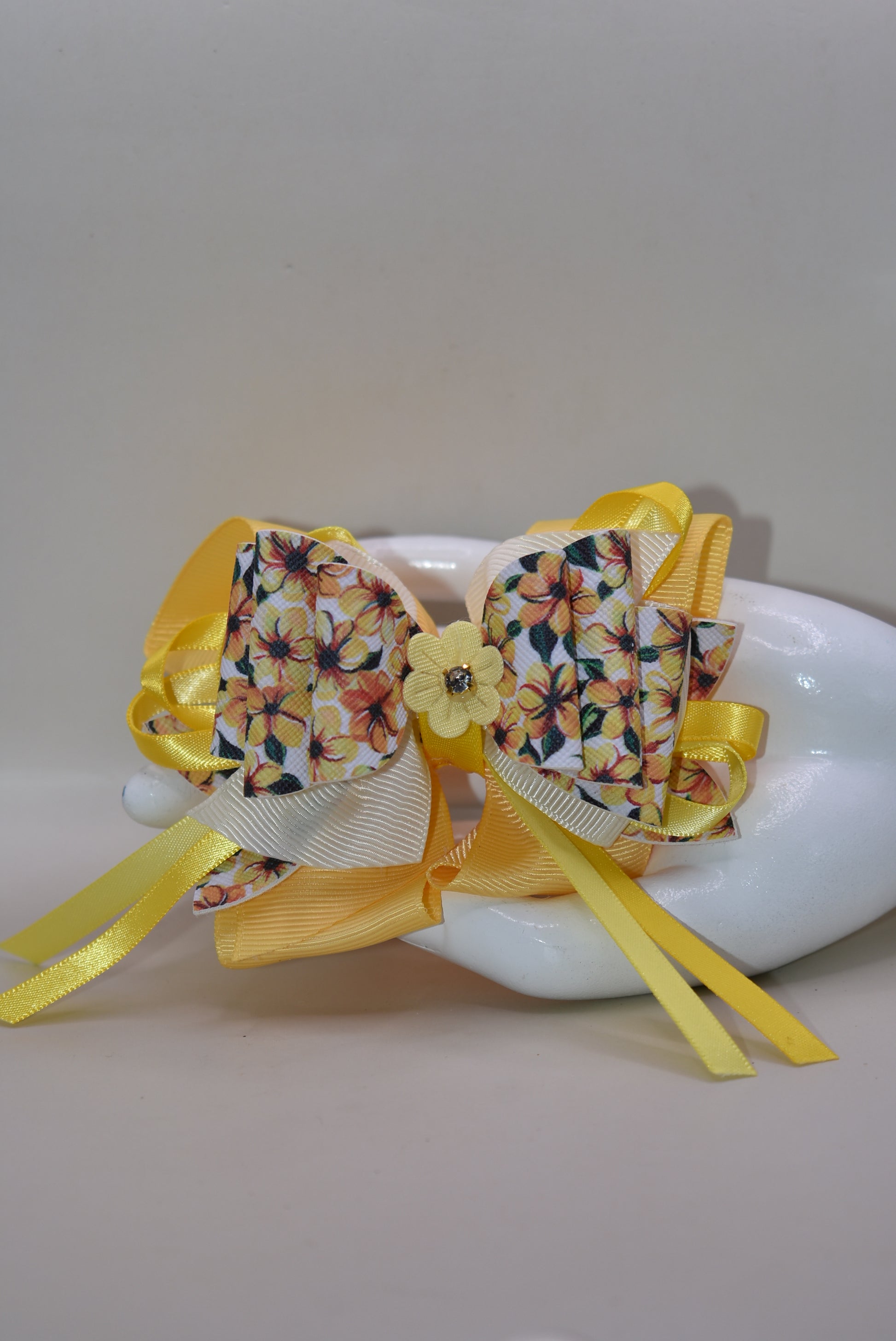 Get ready to turn heads with this vibrant yellow floral bow! 🌼 Layered ribbons and faux leather create gorgeous dimension, while a delicate yellow flower topped with a sparkling crystal adds the perfect finishing touch. ✨ The secure alligator clip keeps your style locked in place all day long. Pure joy in bow form! 💛