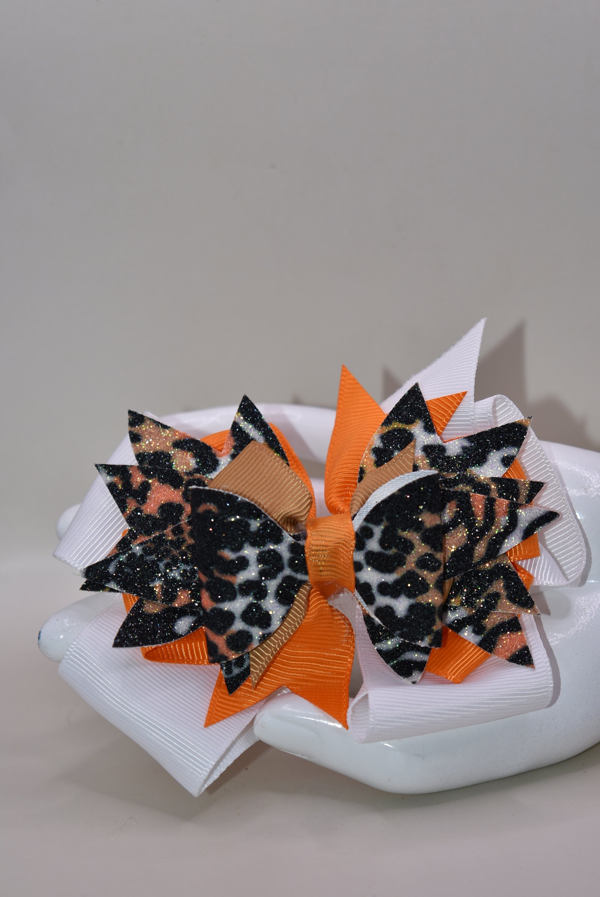 🐆 Get ready to roar with style! This fabulous leopard print faux leather bow features vibrant layers of colorful ribbon that'll make heads turn. The playful animal print mixed with those eye-catching ribbon details creates the perfect pop of personality for any look. Secured with a wrapped alligator clip on the back, it's easy to style and built to stay put. A fun, fierce accessory that's bound to become an instant favorite! 🎀✨